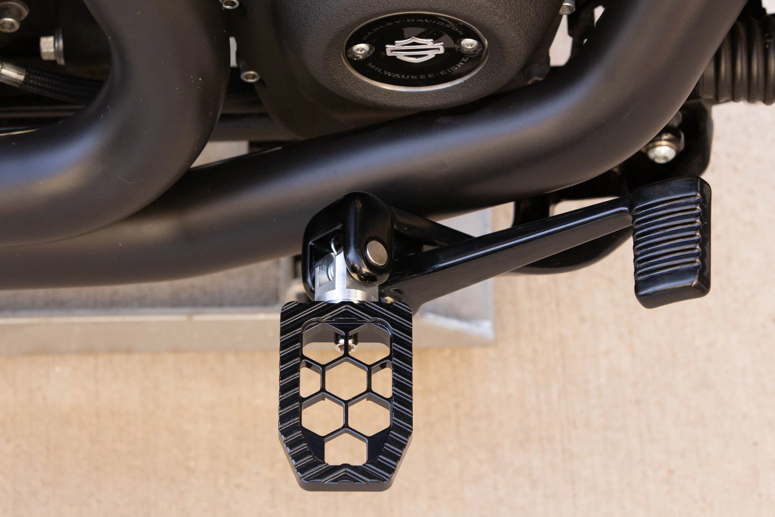 Vengeance Customs rider footpegs for 2018+ Harley-Davidson Softail in Black Eclipse, installed on motorcycle