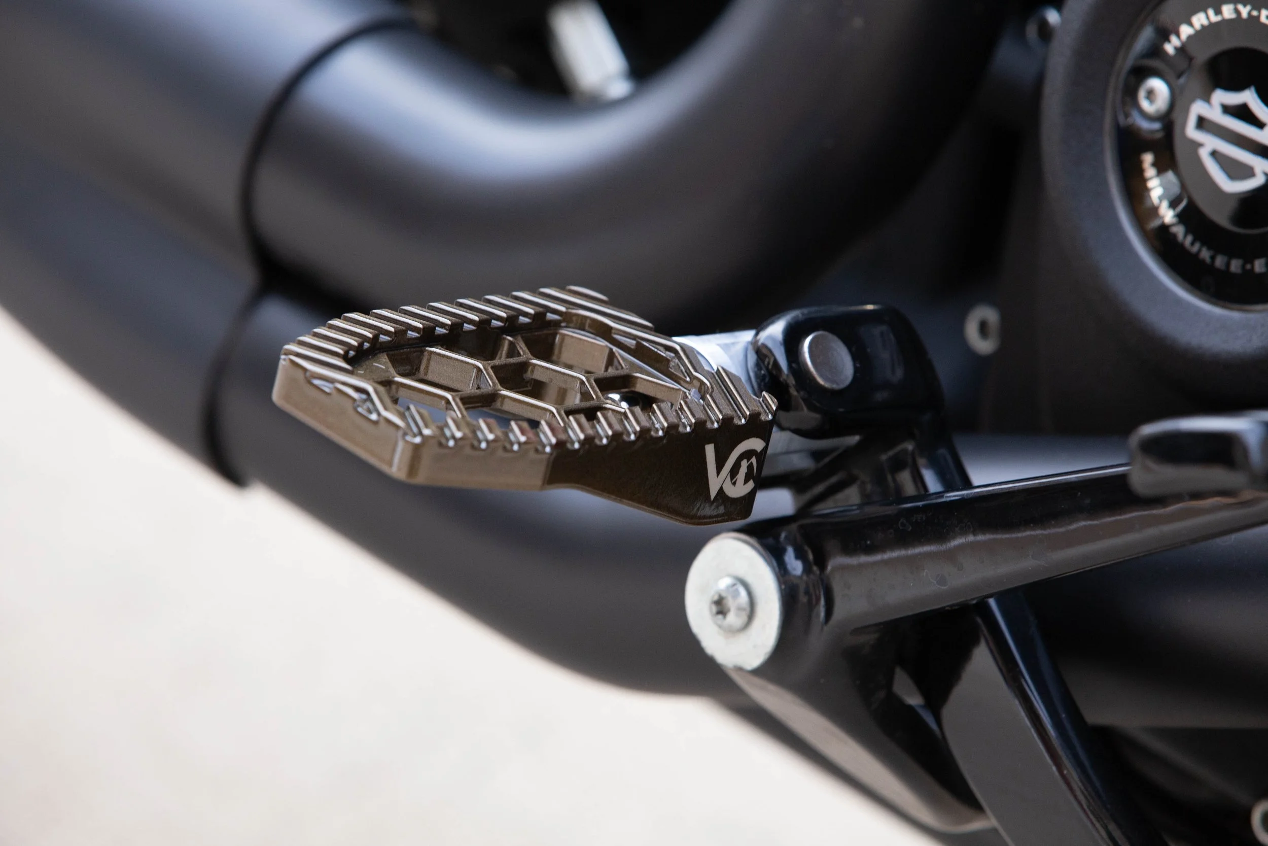 Vengeance Customs rider footpegs for 2018+ Harley-Davidson Softail in Bronze Bound Finish, installed on motorcycle