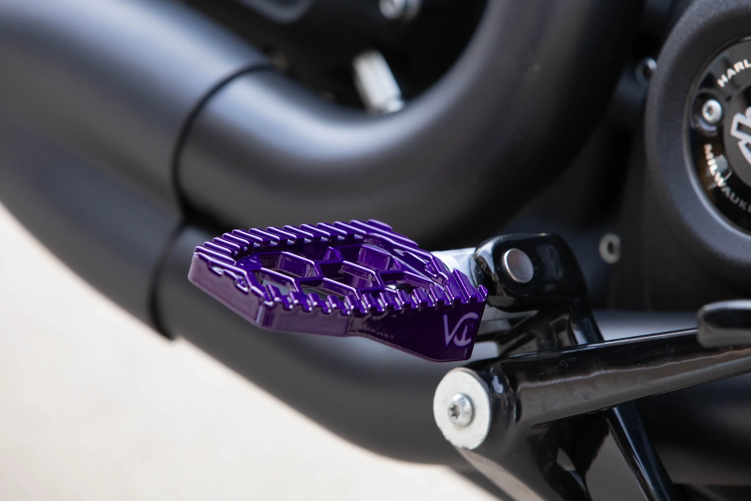 Vengeance Customs rider footpegs for 2018+ Harley-Davidson Softail in Purple Oblivion Finish, installed on motorcycle