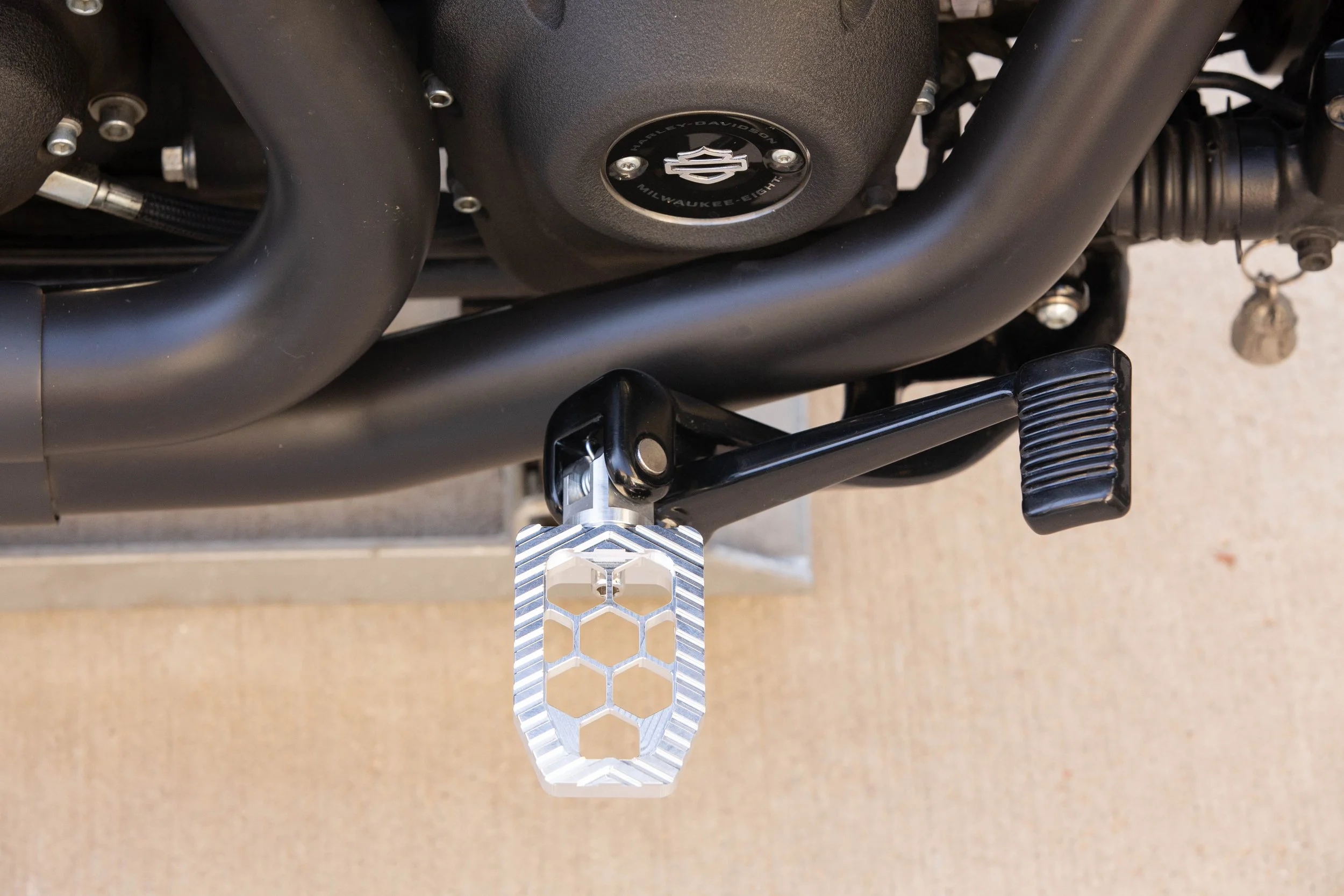 Vengeance Customs rider footpegs for 2018+ Harley-Davidson Softail in Raw Finish, installed on motorcycle