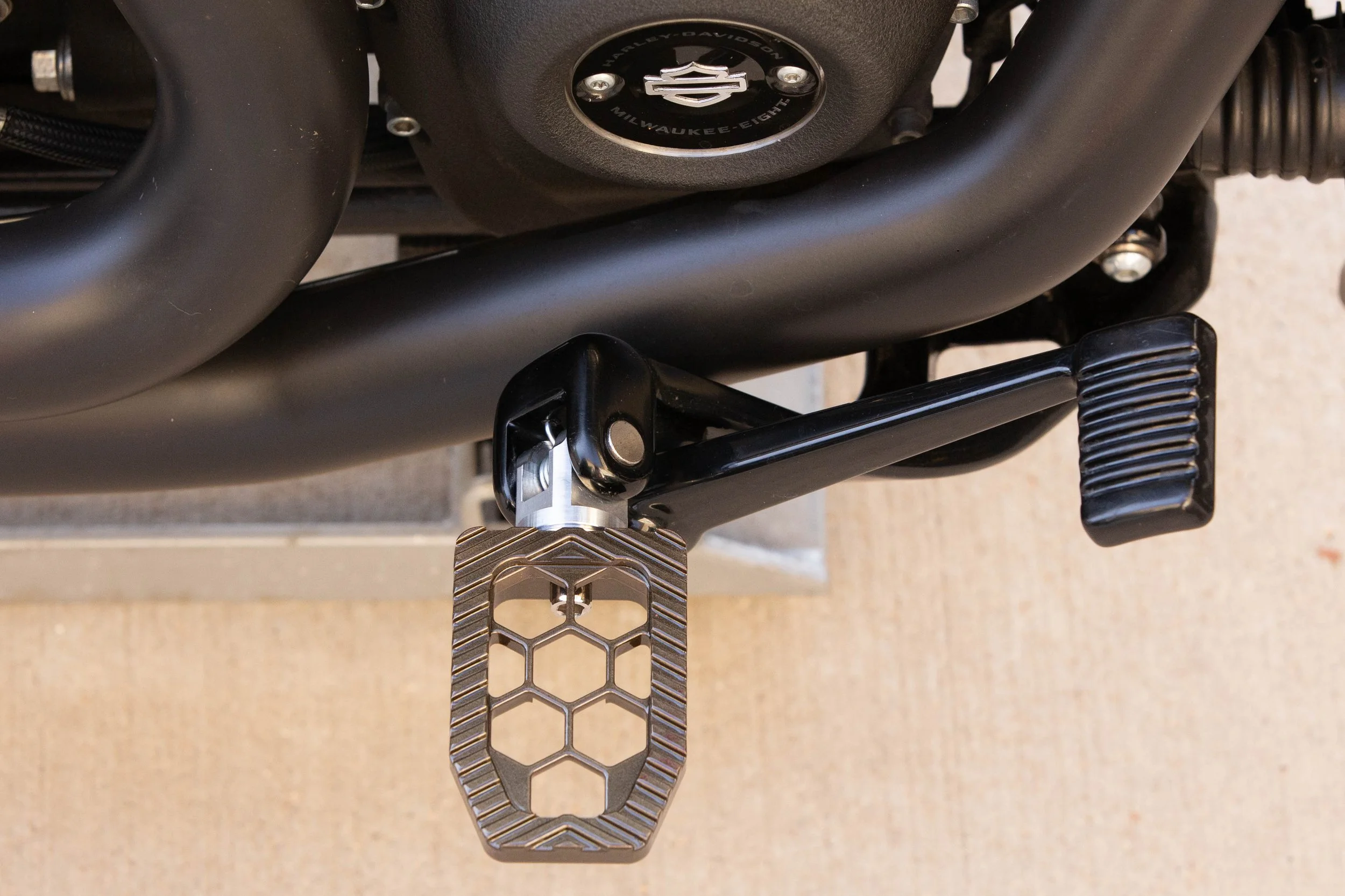 Vengeance Customs rider footpegs for 2018+ Harley-Davidson Softail in Bronze Bound Finish, installed on motorcycle
