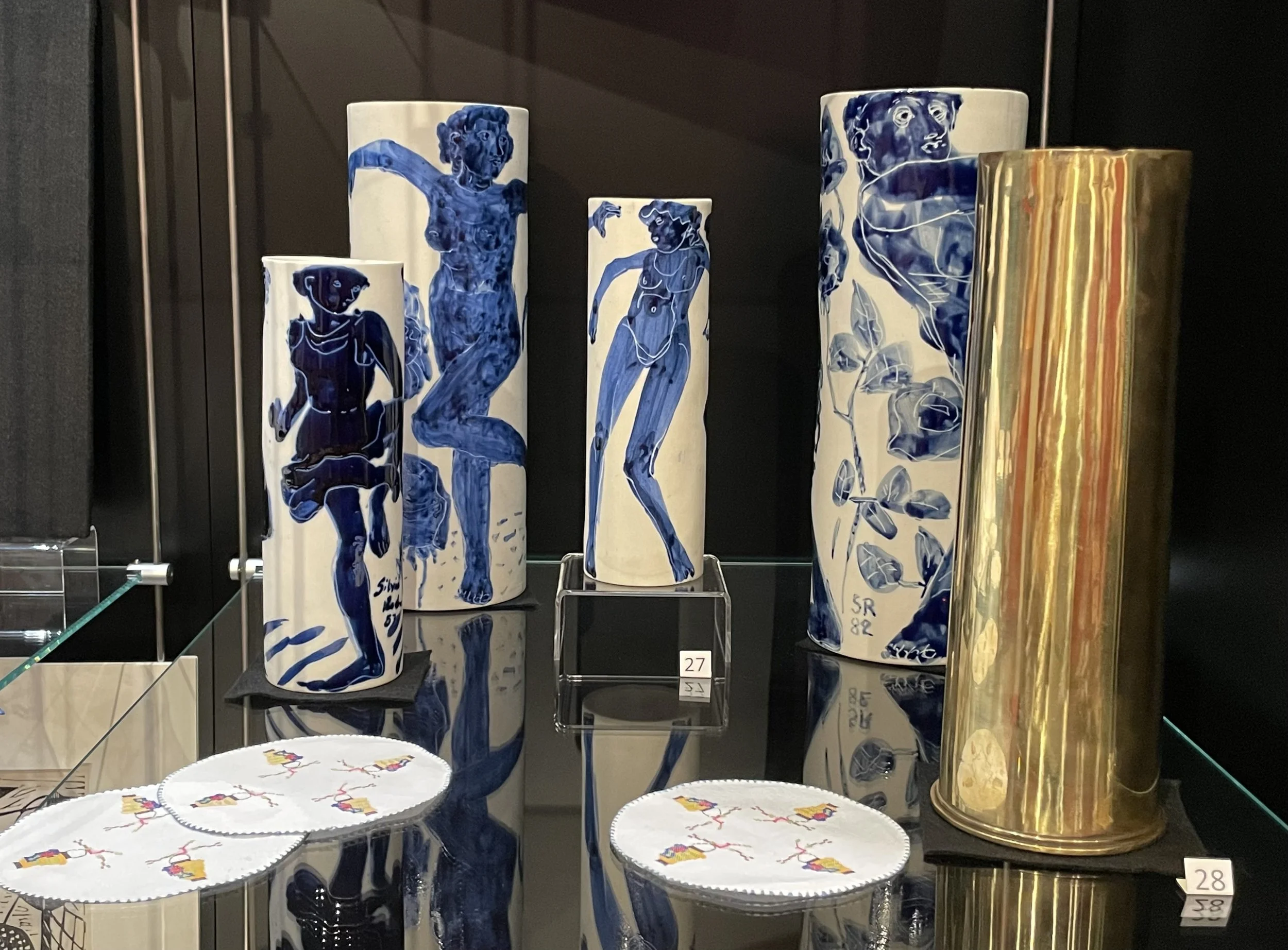 Curiosity cabinet with glazed porcelain vases by Silvia Radu 1981-1986, embroideries by Shula Ullmann, inherited ammunition canister.