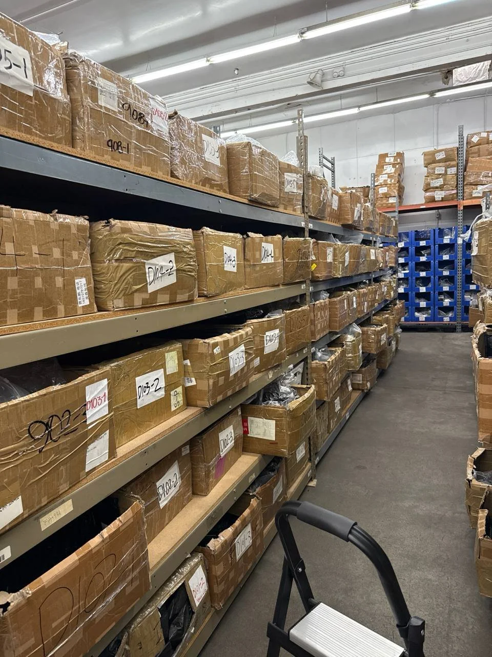 A person working at a desk with various color swatches, a tablet, keyboard, and computer monitor.
