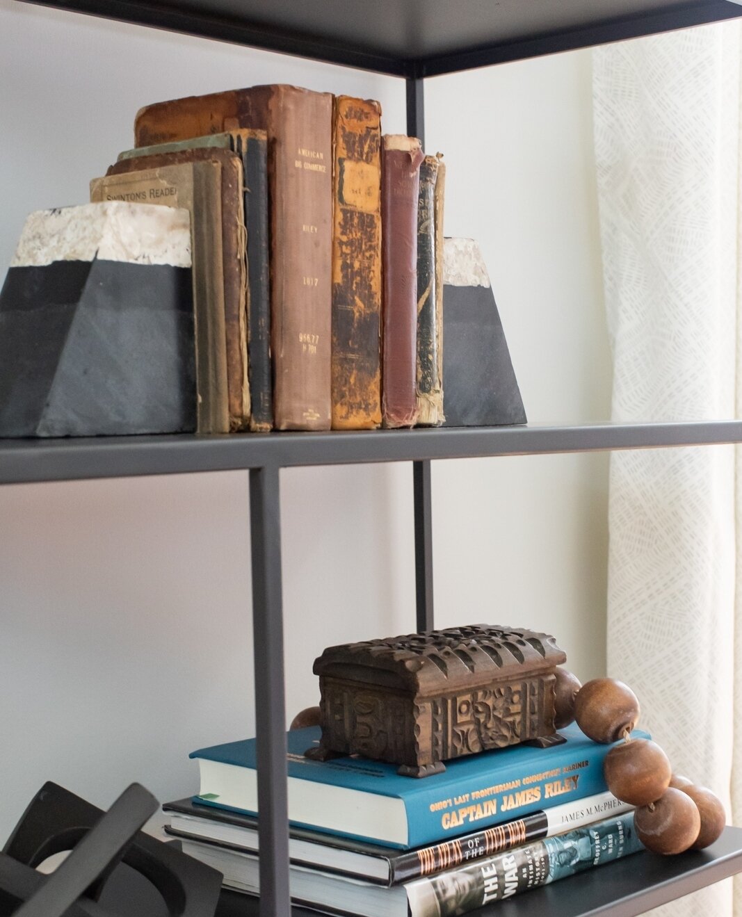 Digging through client keepsakes is one of many things we do to curate a home that is personable and comfortable. This client's grandfather has a rich history in being a Captain and protecting our country. We paired already owned books with updated a