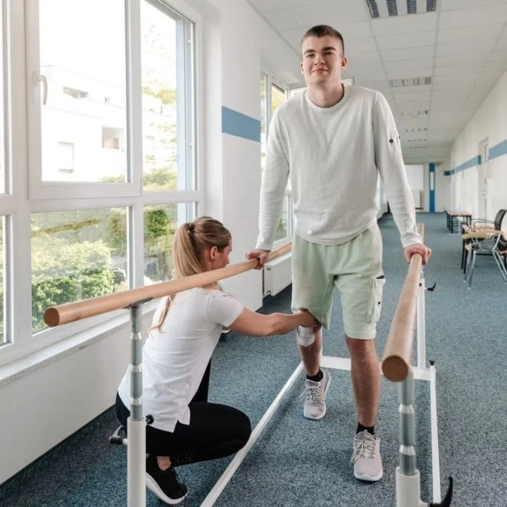 Man using parallel bars during meniscus surgery rehabilitation therapy.