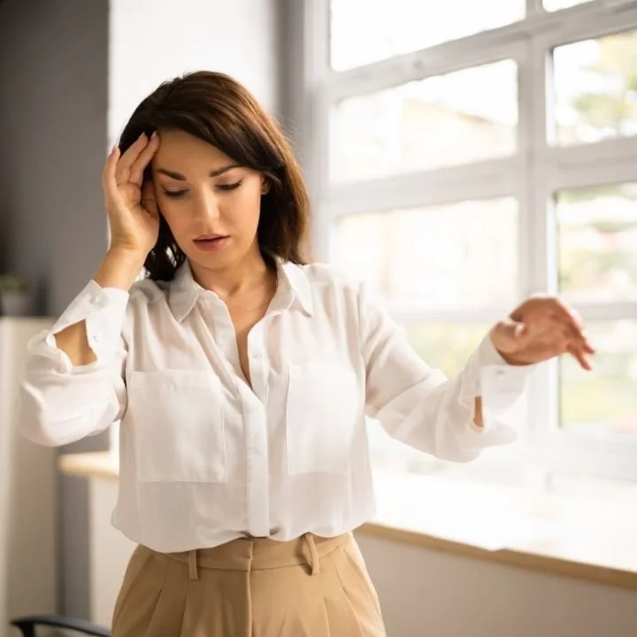 Woman losing balance during a dizziness episode caused by a vestibular disorder.