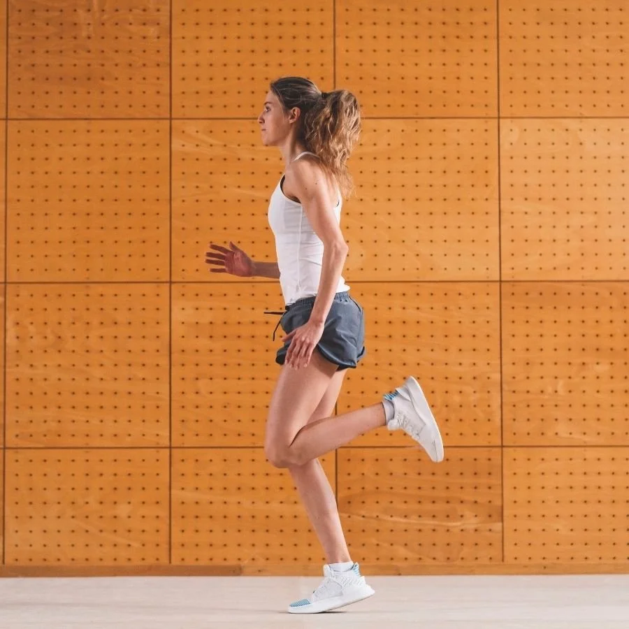 Runner performing butt kicks drill for warm-up.