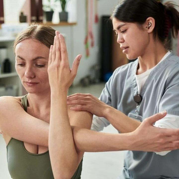 Therapist assisting patient with controlled shoulder range of motion exercise.