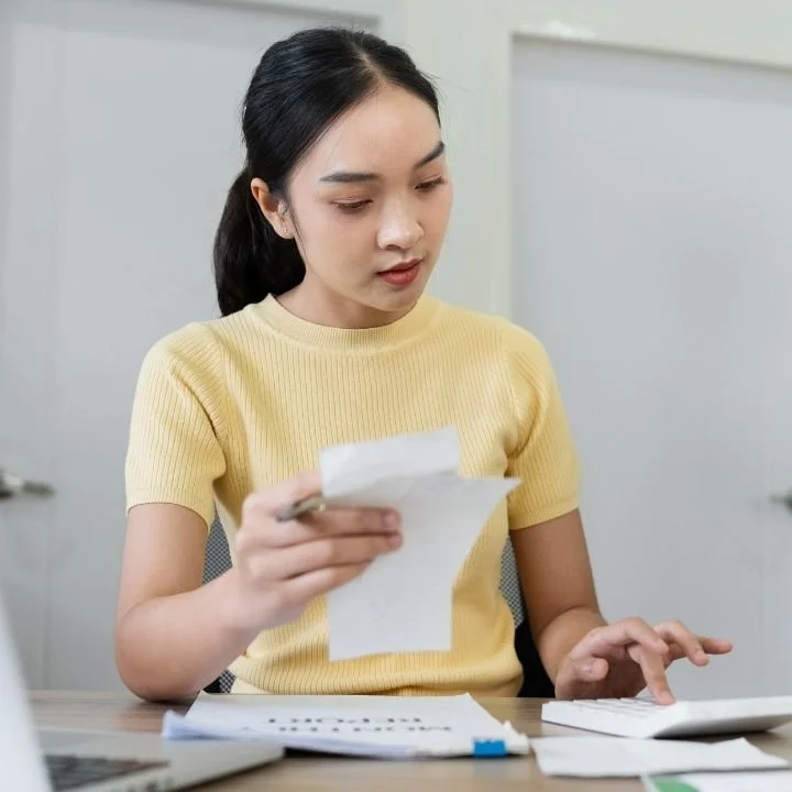 Patient calculating physical therapy costs and reviewing medical expenses at home.