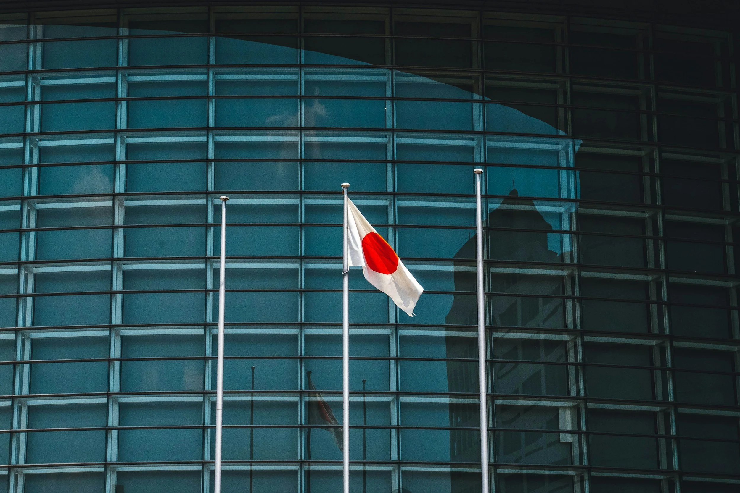 Japanese flag in front of a modern glass building