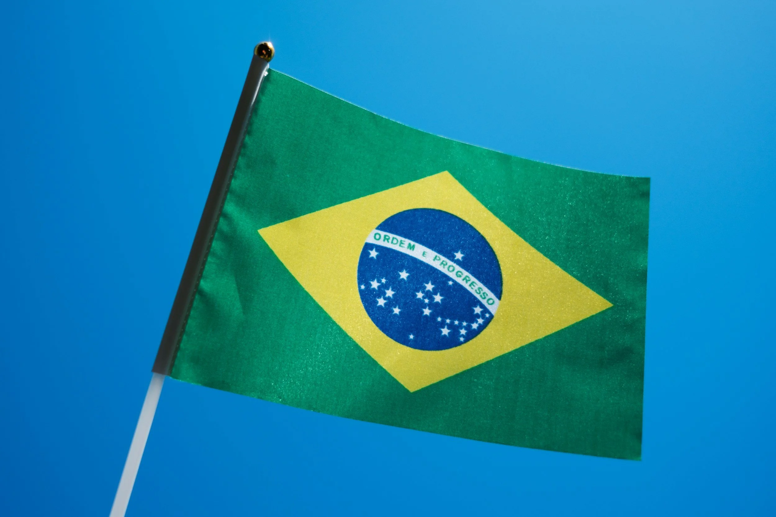 Brazilian flag waving against a blue sky
