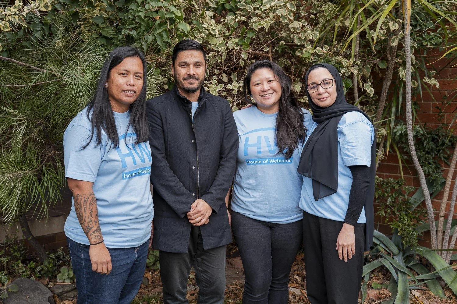 Marie, Sayed, Ruth and Hoorieh taking a group photo to represent workplace engagement at House of Welcome