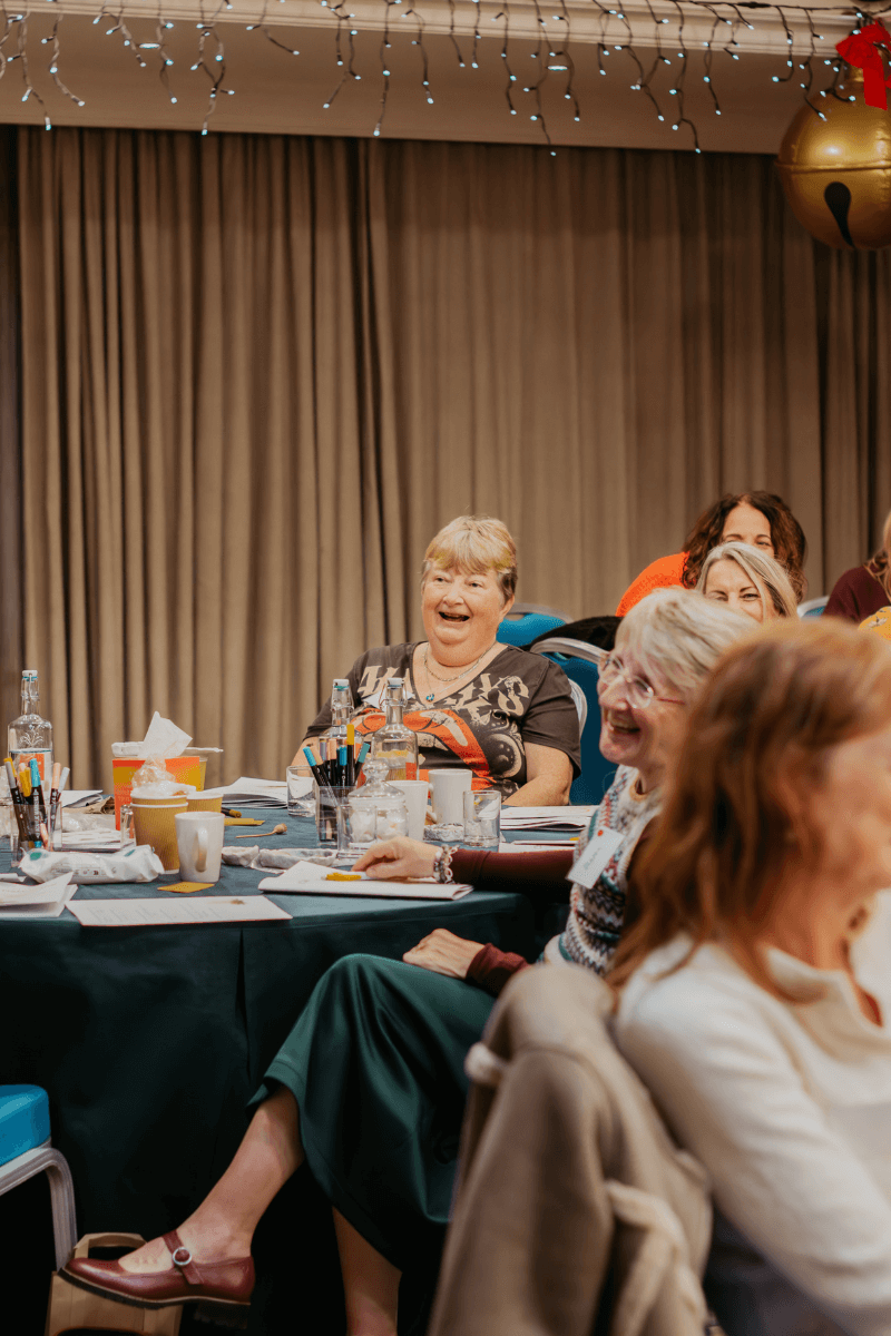A group of widows smiling together after a heartfelt and uplifting moment during the Christmas retreat