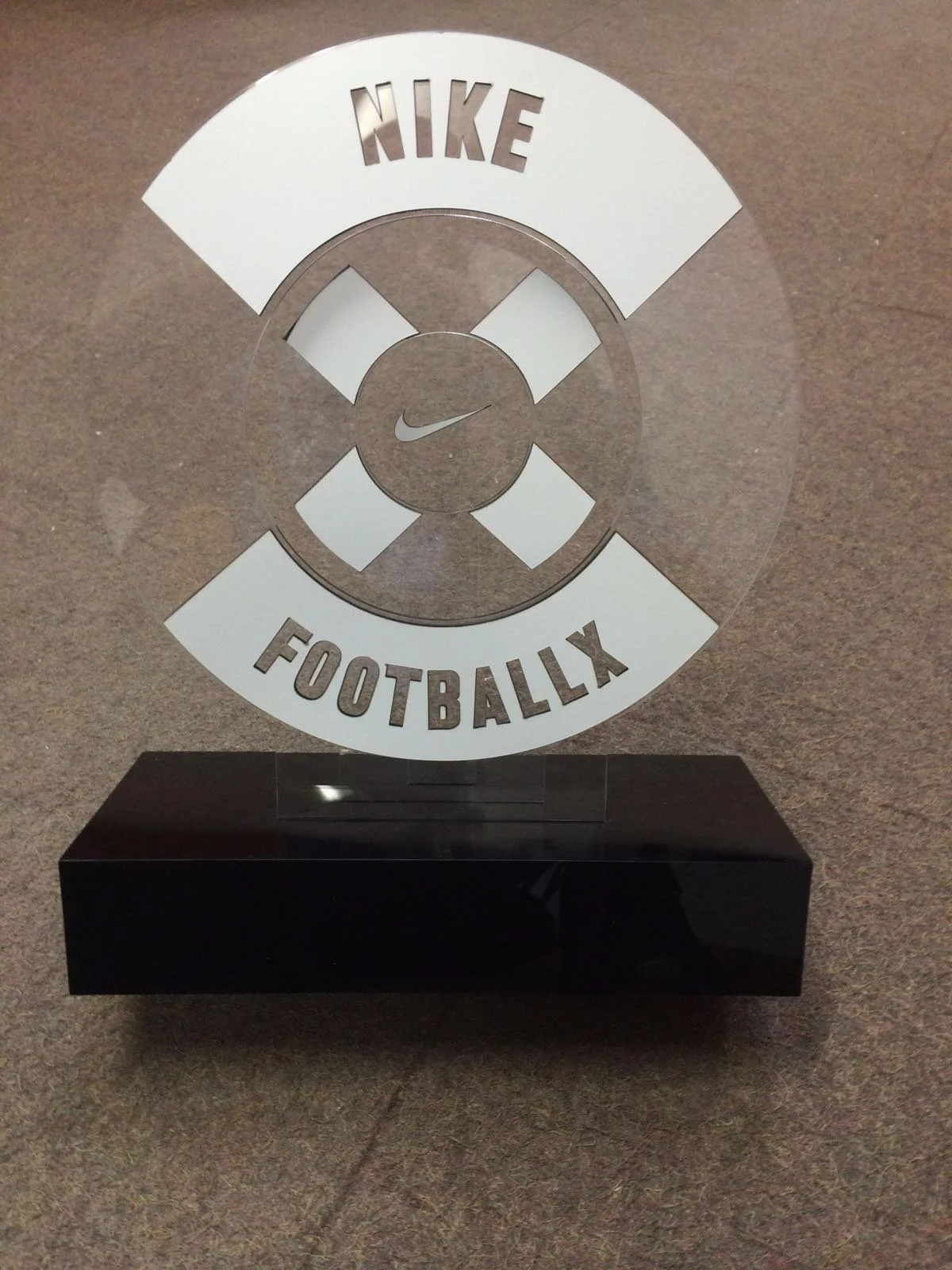 An acrylic, custom decorated football award with multi-dimensional support on a custom cut base.