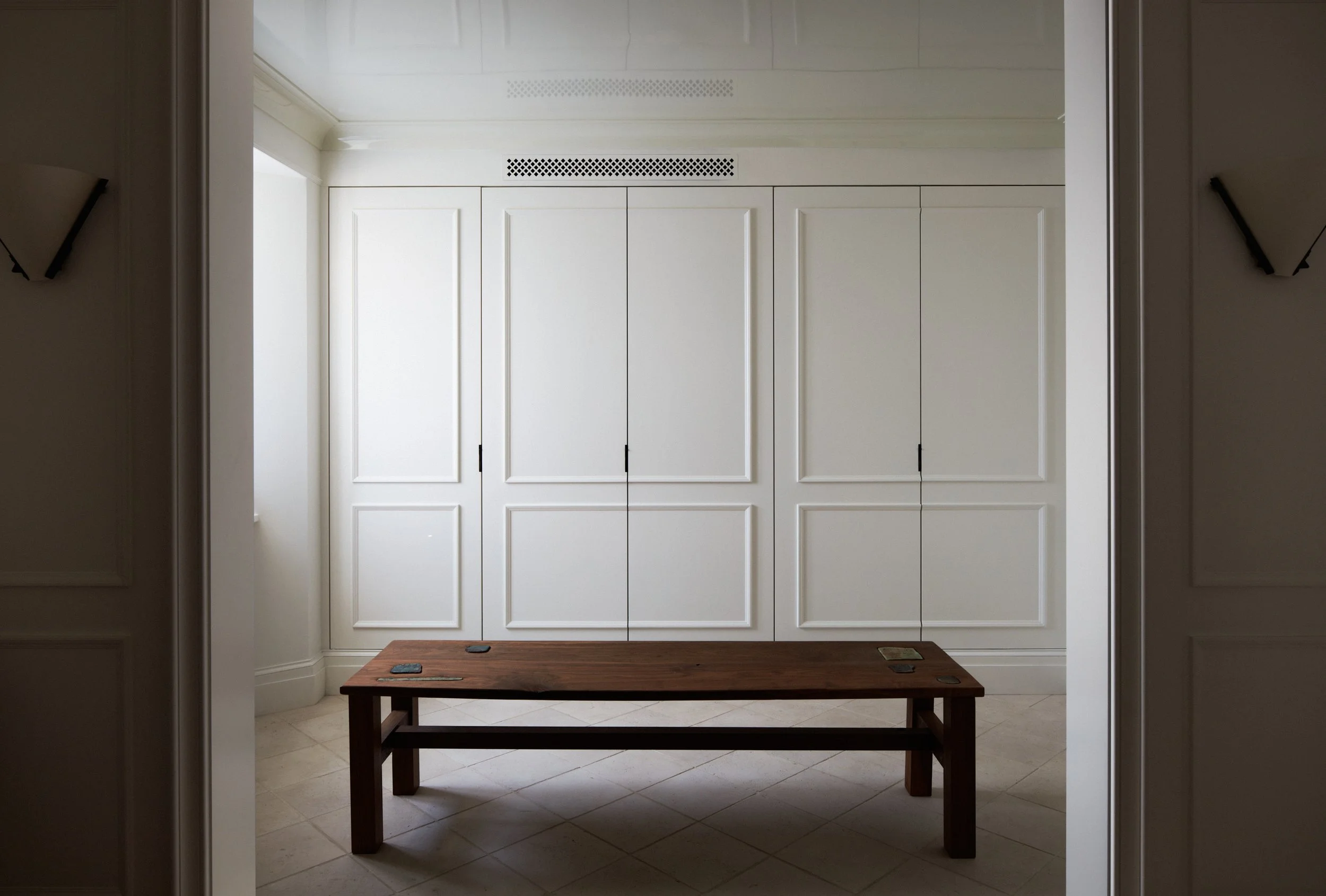 Bench in a room with closet doors behind.
