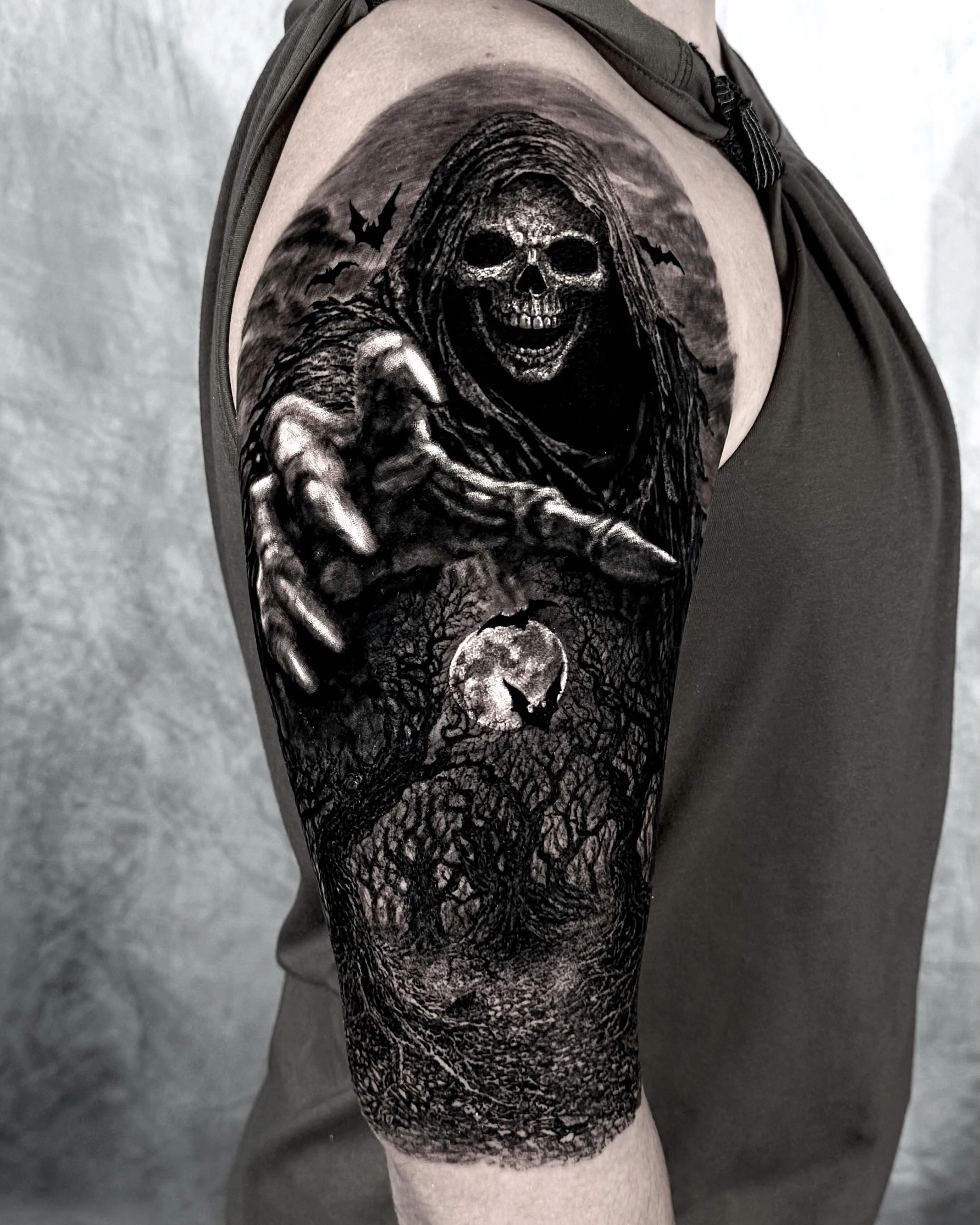 Grim reaper reaching out his hand realism tattoo on the upper arm by Etgar Oak
