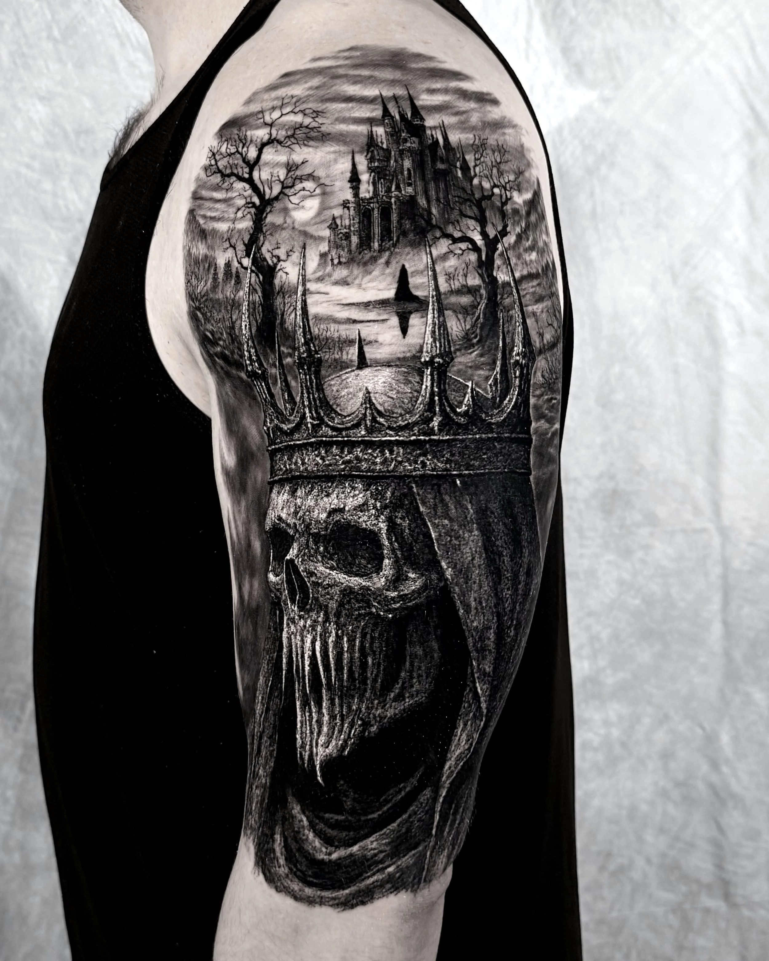 Skull king with castle crown realism tattoo on the upper arm by Etgar Oak