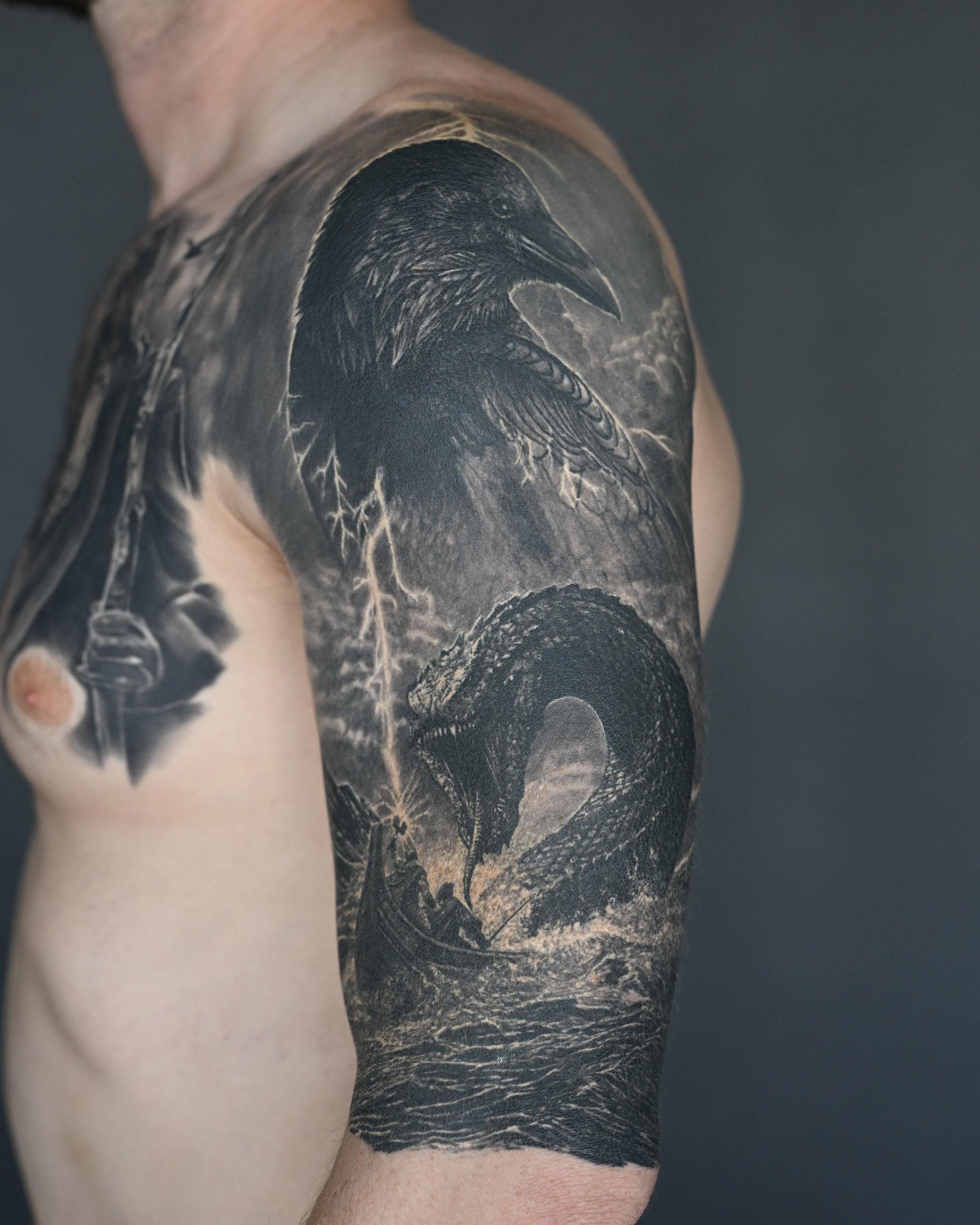 Healed raven, snake and lightning realism tattoo on the upper arm by Etgar Oak