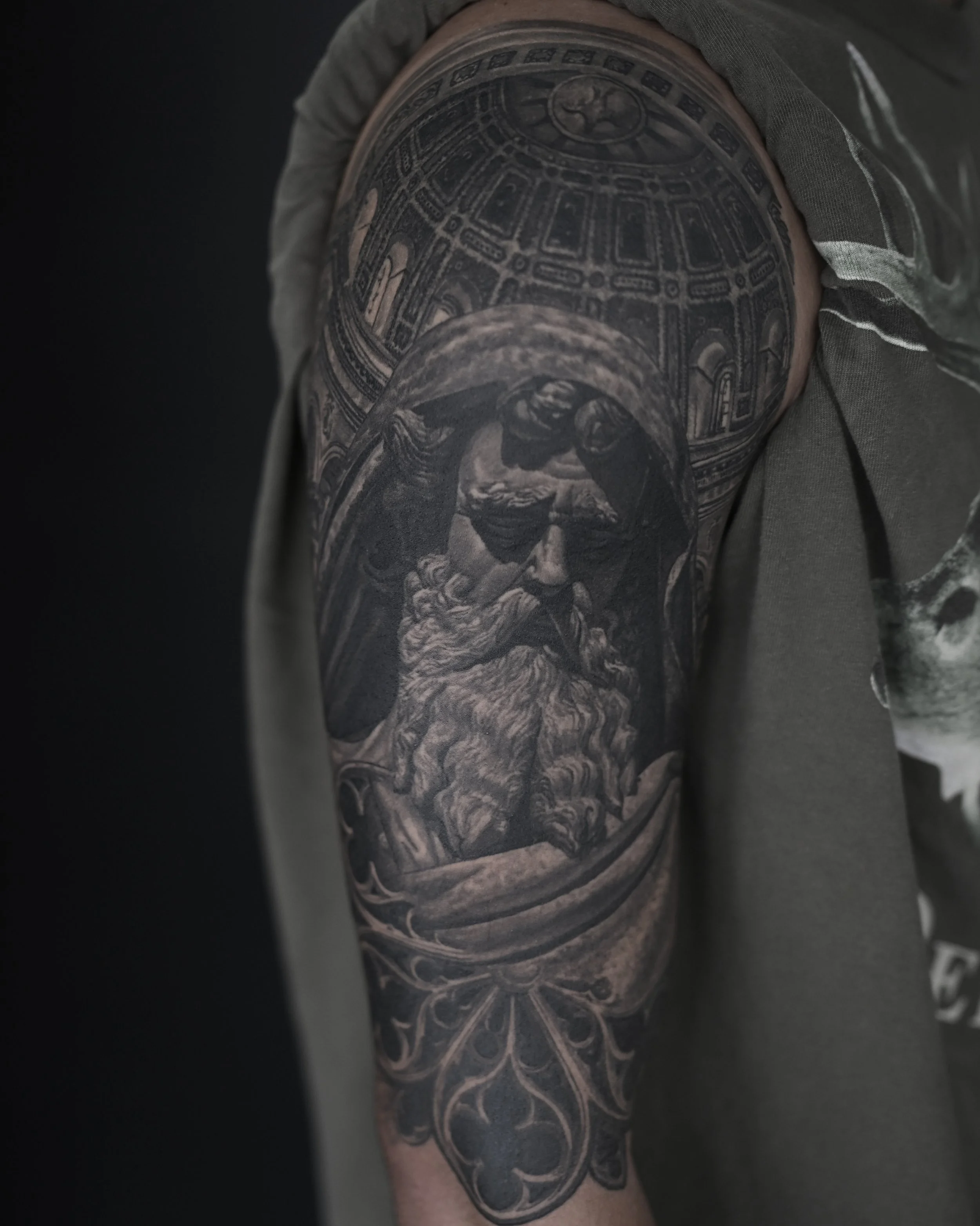 Healed bearded god and cathedral dome realism tattoo on the upper arm by Etgar Oak