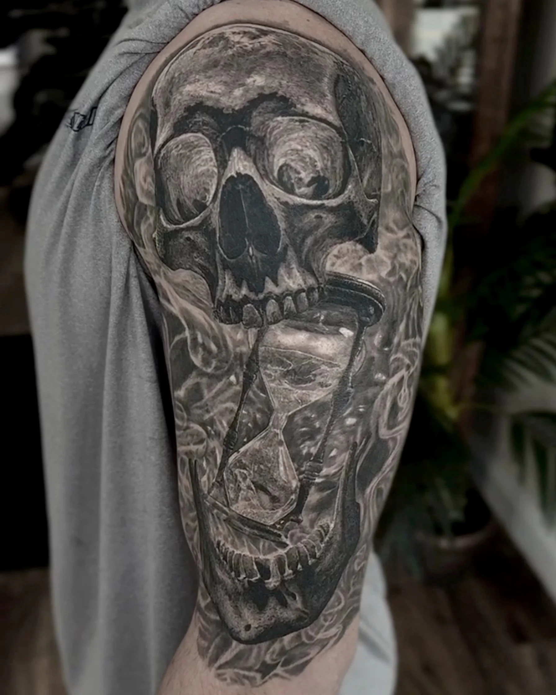 Healed skull and hourglass realism tattoo on the upper arm by Etgar Oak