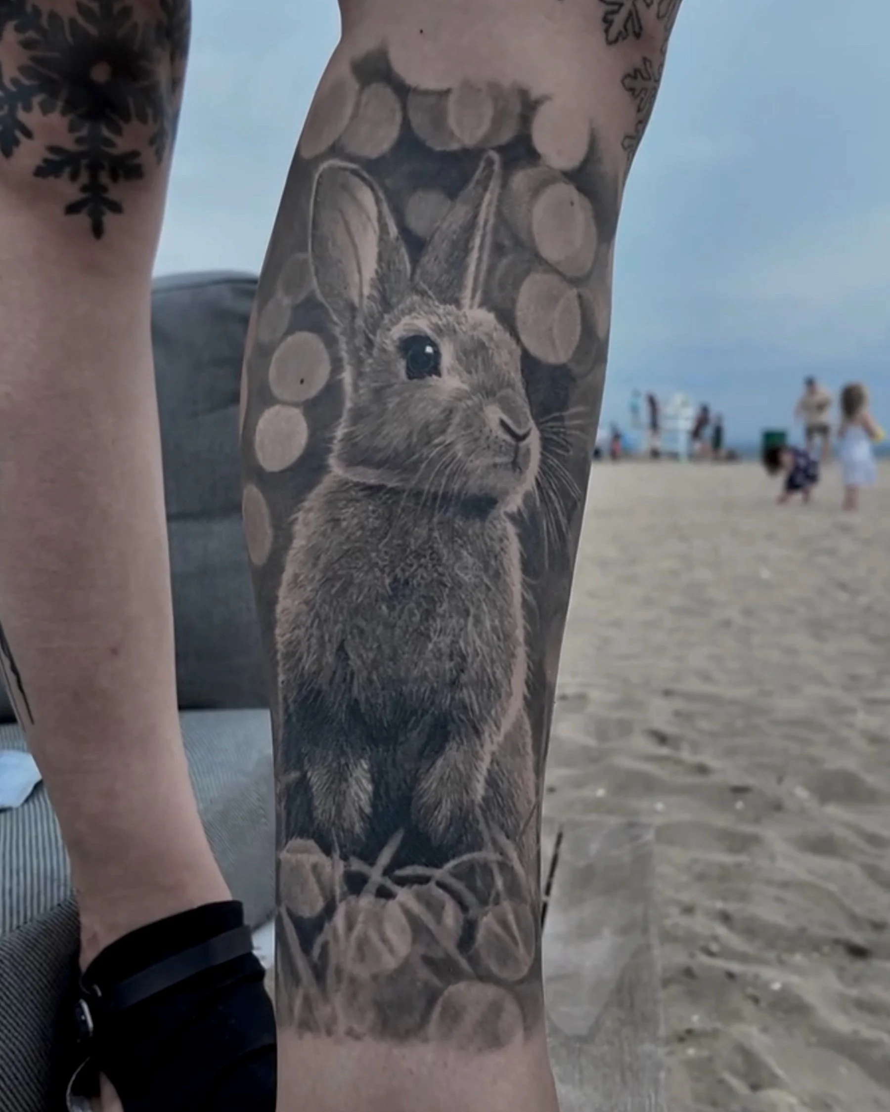 Healed rabbit with bokeh lights realism tattoo on the lower leg by Etgar Oak
