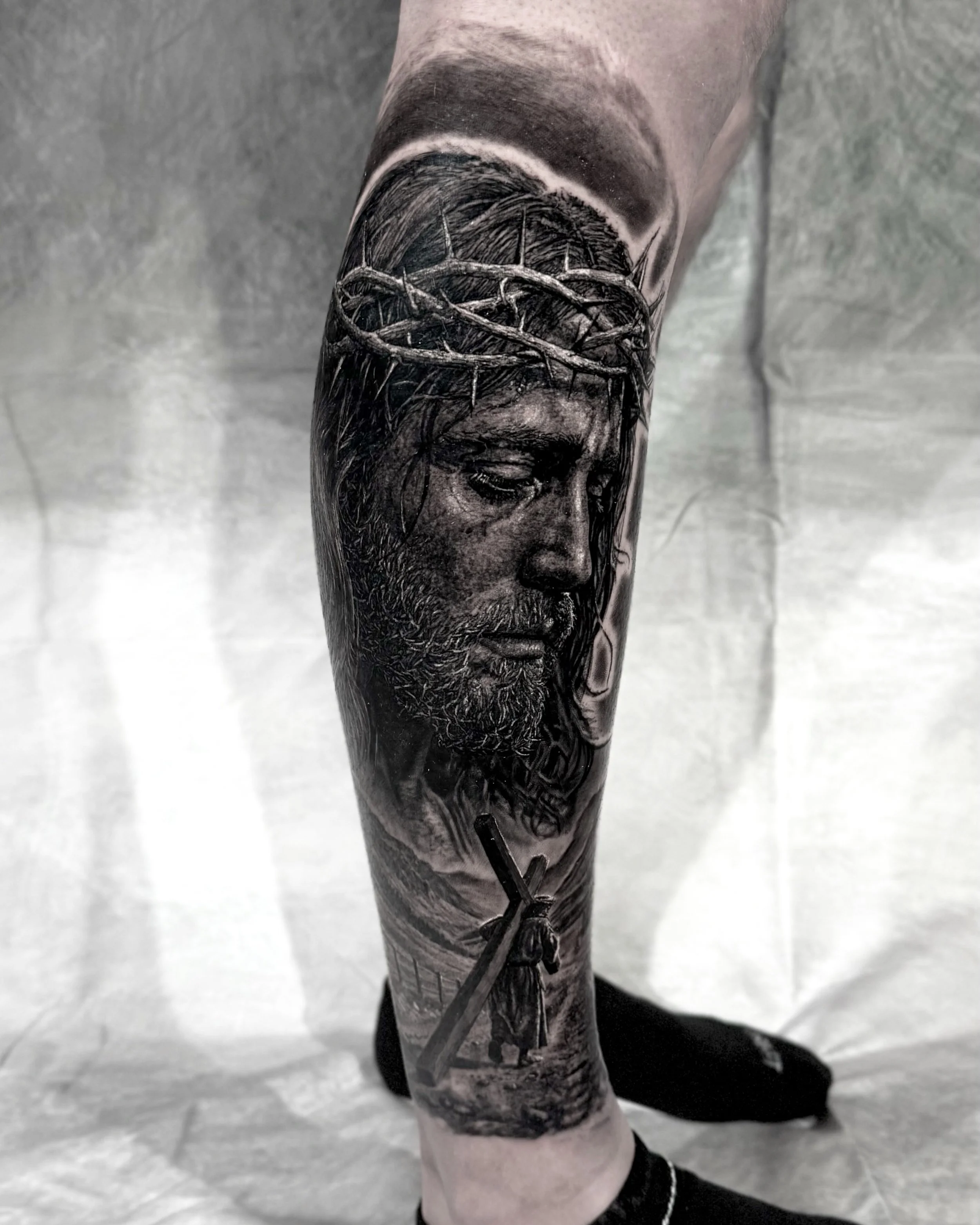Jesus in profile with crown of thorns realism tattoo on the calf by Etgar Oak
