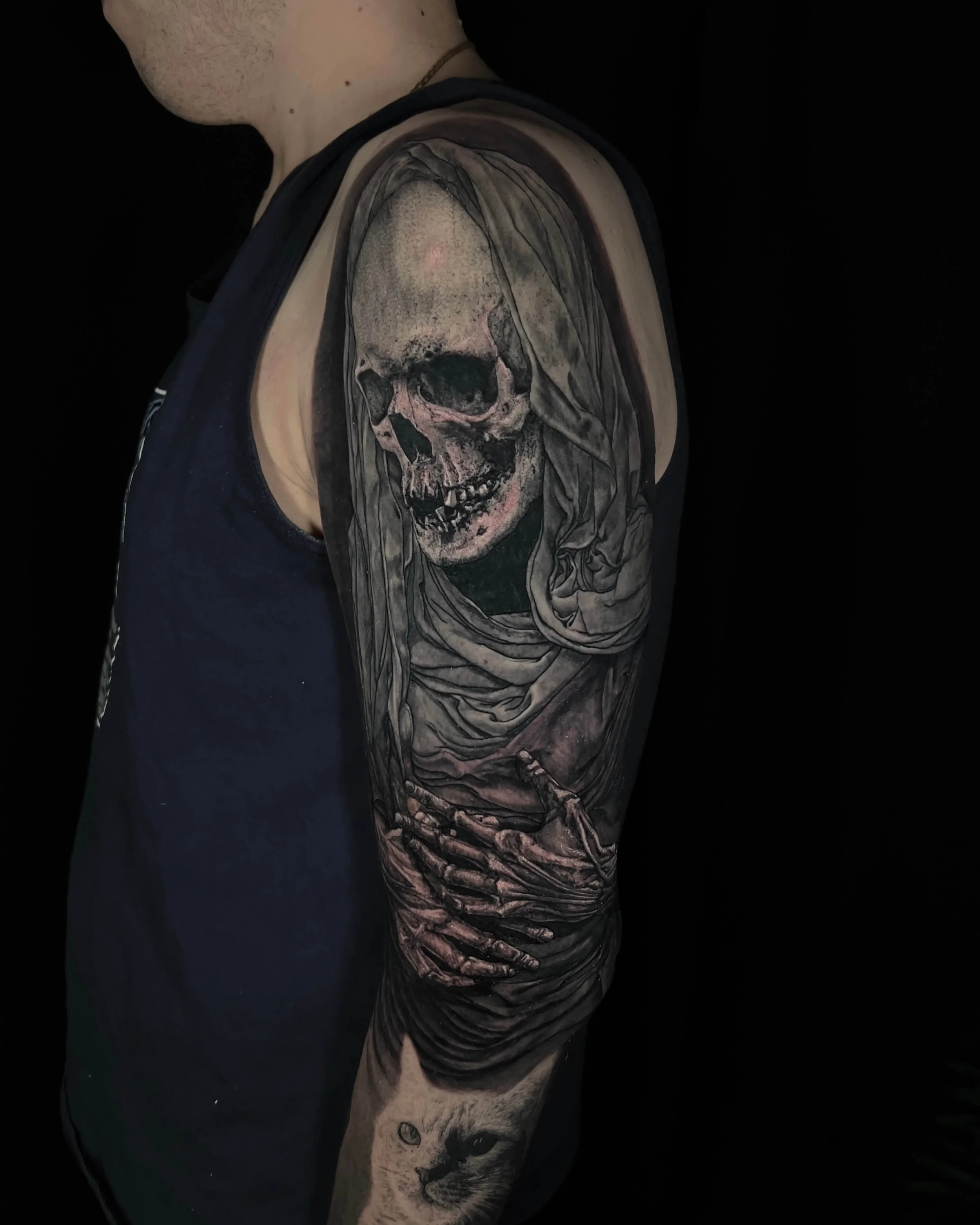 Veiled skeleton with clasped hands realism tattoo on the upper arm by Etgar Oak