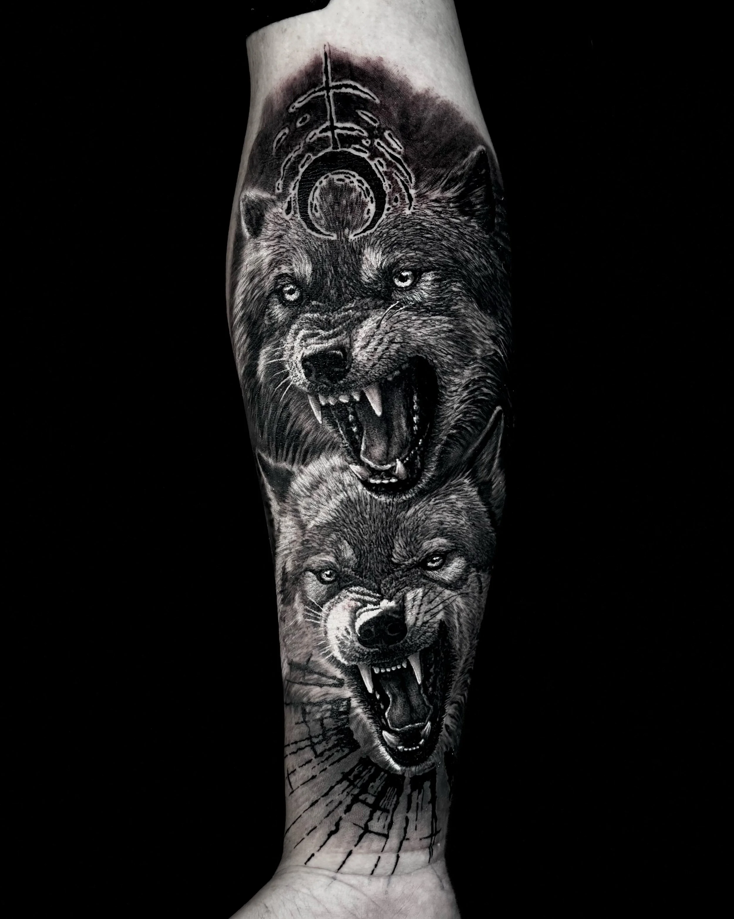 Two snarling wolves realism tattoo on the forearm by Etgar Oak
