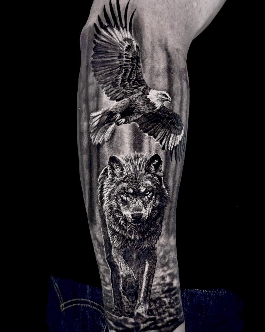 Eagle and wolf realism tattoo on the forearm by Etgar Oak