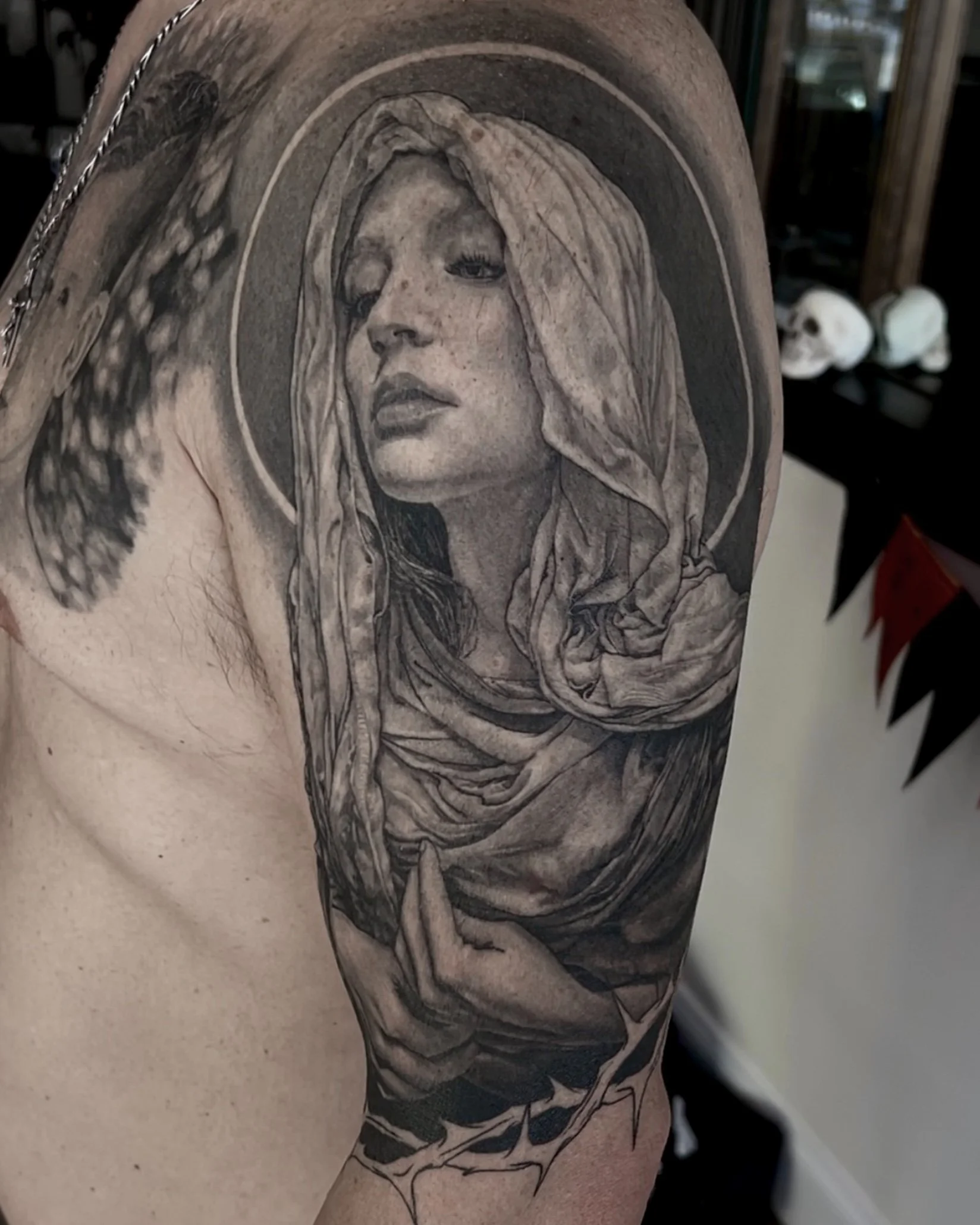 Healed hooded woman with halo realism tattoo on the upper arm by Etgar Oak