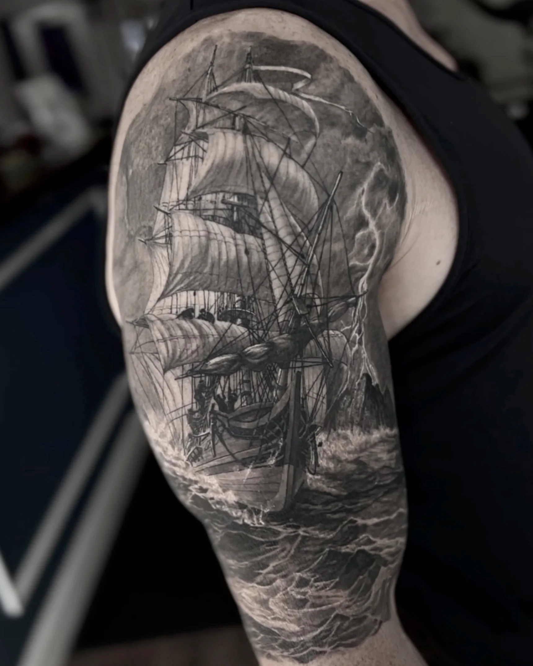 Healed sailing ship in a storm realism tattoo on the upper arm by Etgar Oak
