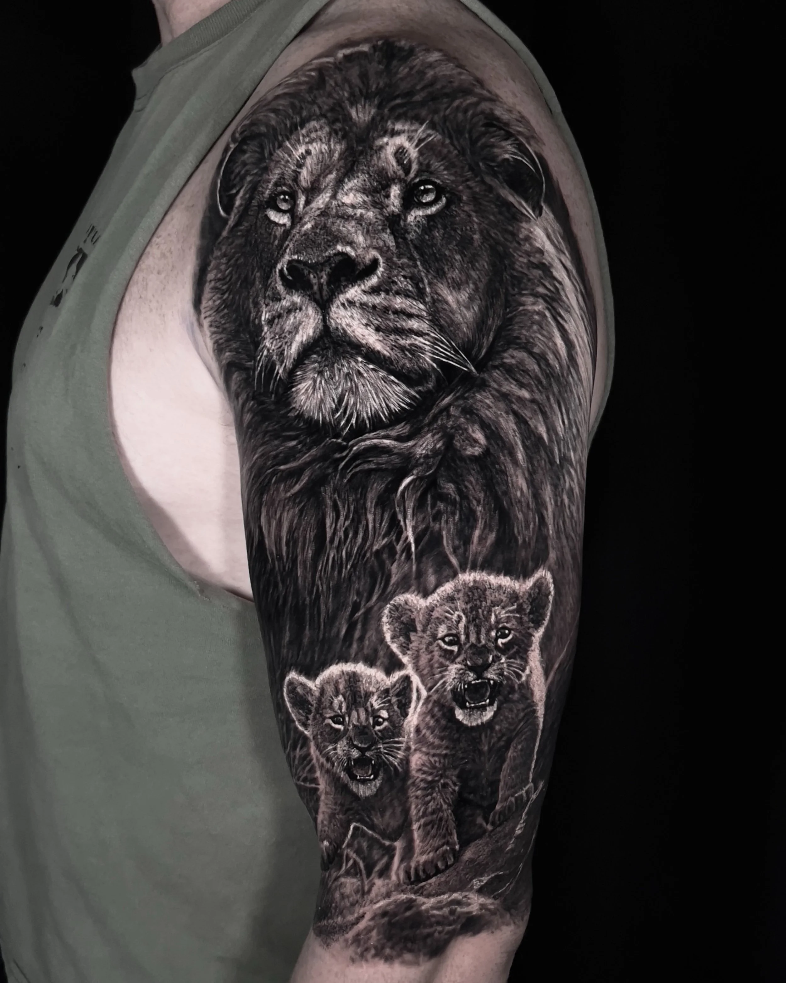 Lion and cubs realism tattoo on the upper arm by Etgar Oak
