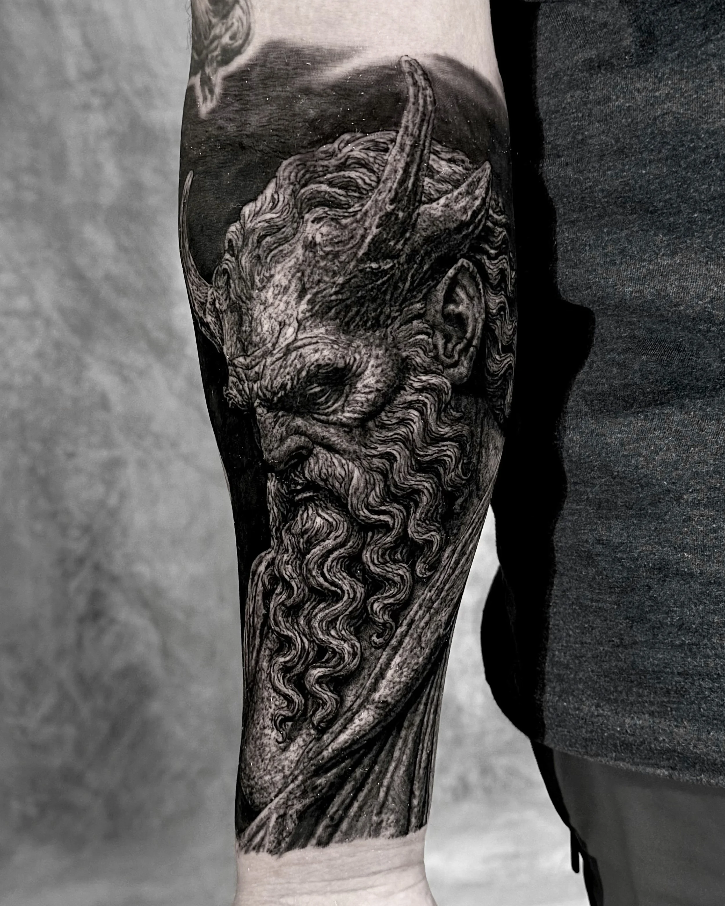 Horned bearded demon realism tattoo on the forearm by Etgar Oak