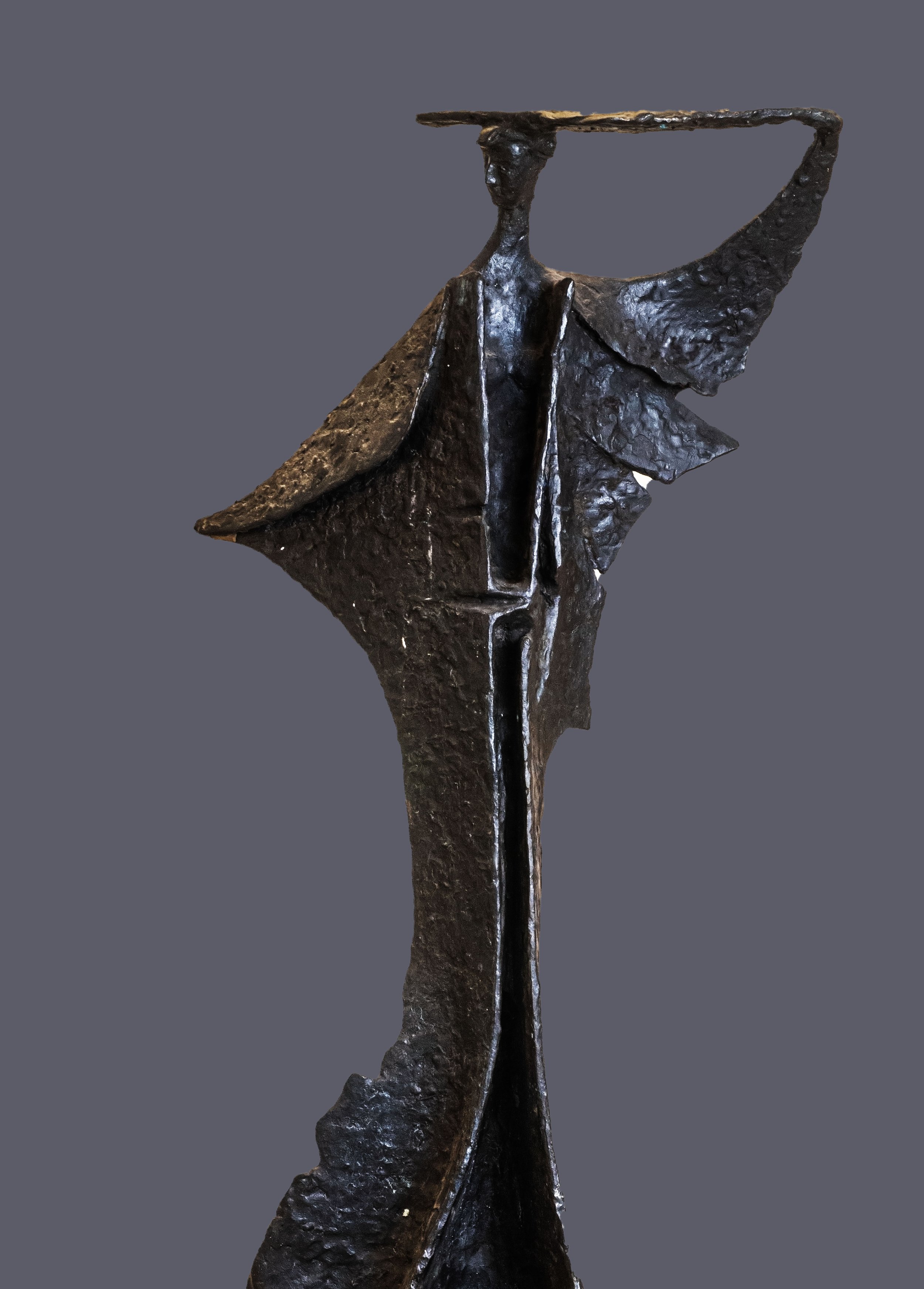 Feminine figure in long and wide dress, with an object lying on her head.