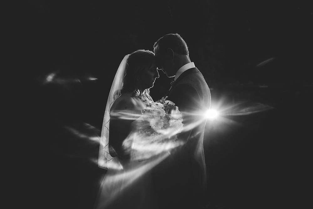 Wedding couple first dance in wooden venue with guests seated and chandeliers at Trillium Resort and Spa