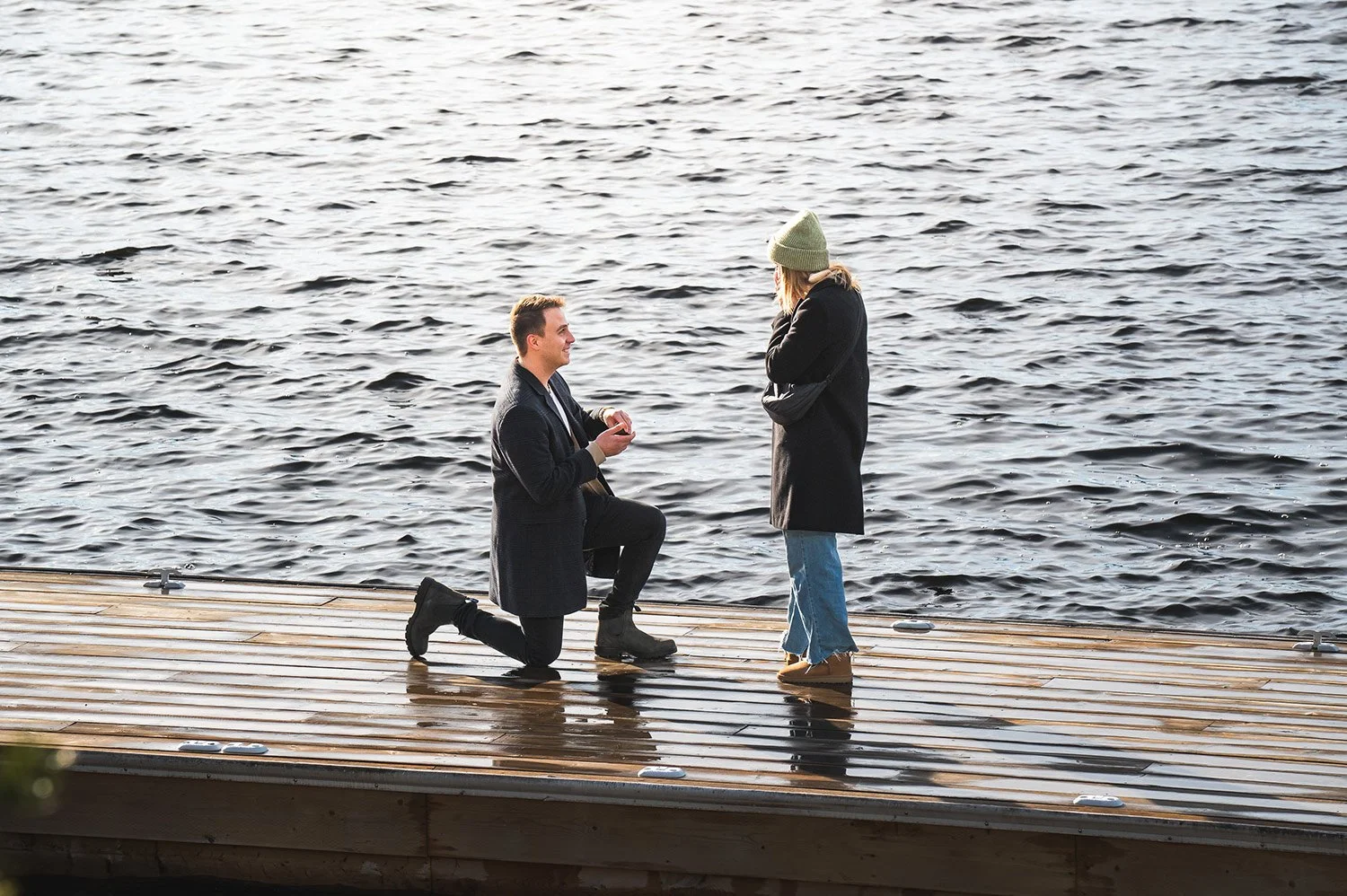 Man proposing to girlfriend on a cottage dock