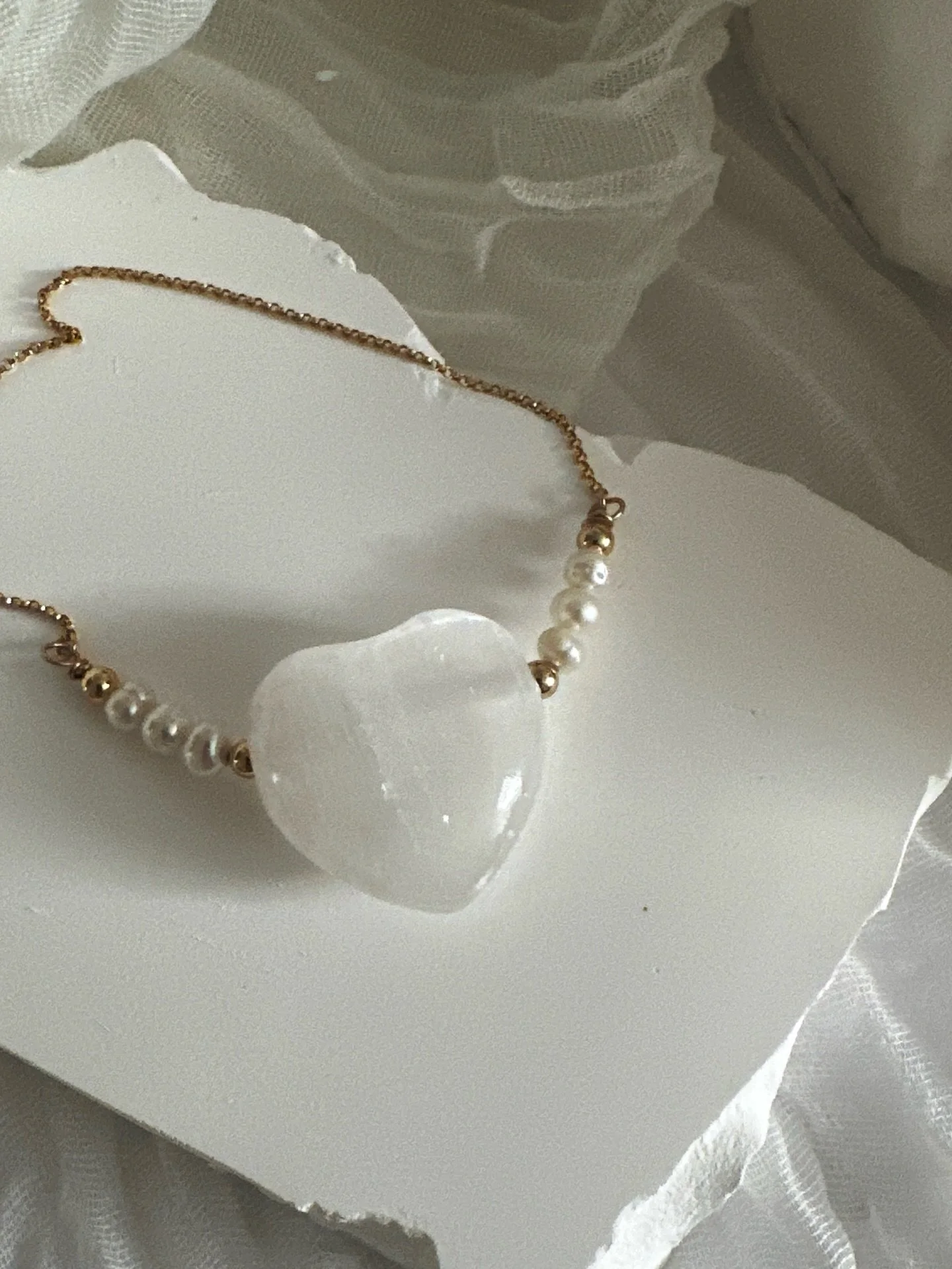 Crafted by hand to feel like a gentle, grounding embrace.

Made with gold-filled elements, freshwater pearls, and a radiant selenite heart,  a piece designed to uplift your energy, and supporting you through every moment.

Selenite is known for its s