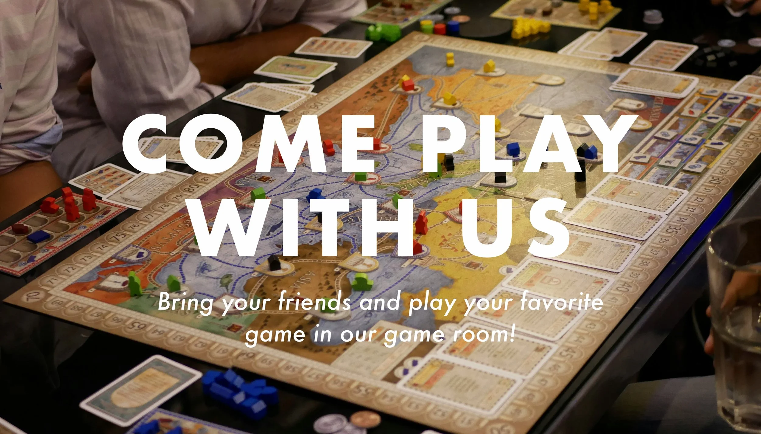 Board game layer out on a table with cards and pieces in front of the players and pieces on the board in various spots. The words “Come Play With Us” are written across the image to promote renting tables to play games at Ray Gun Comics.