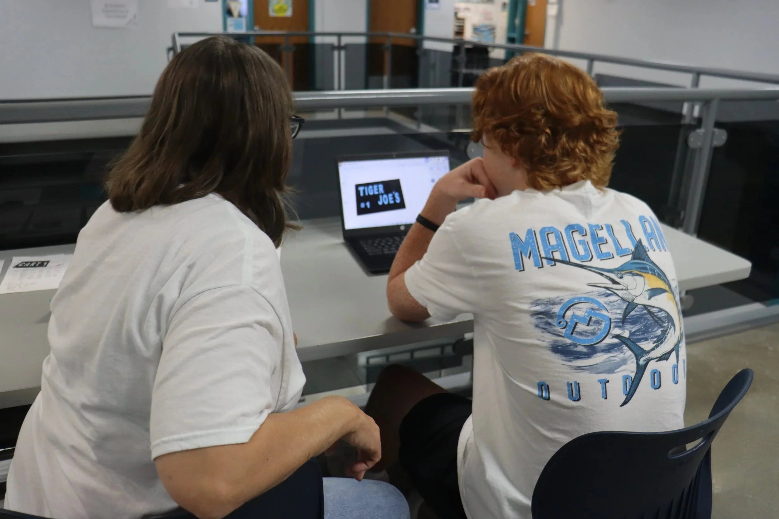 Spradley sits down with Viola to go over his design. Spradley met with each student to discuss color schemes, dimensions and overall design ideas for what she wanted. They decided on Eisenhower colors: black, blue and grey. “It will be pretty cool