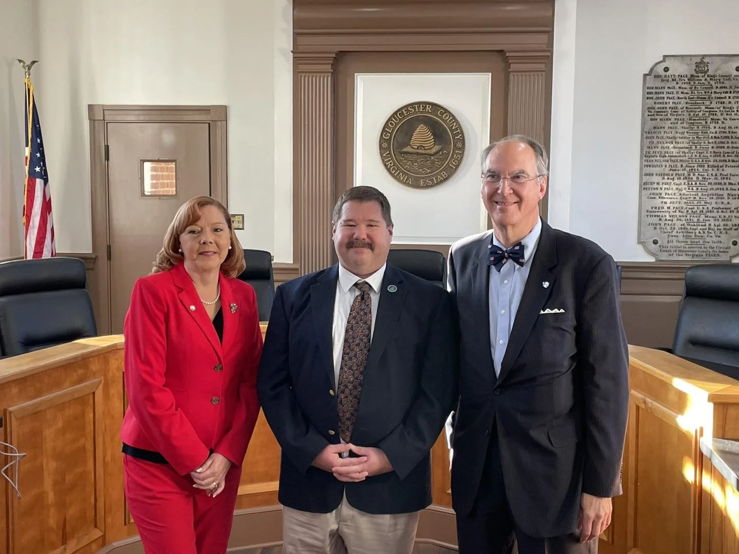 A lady and two men standing in a government building.