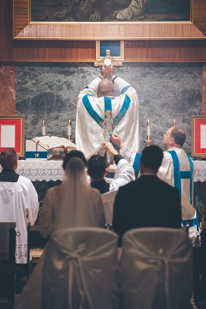 Priest holding a host during a Catholic wedding ceremony