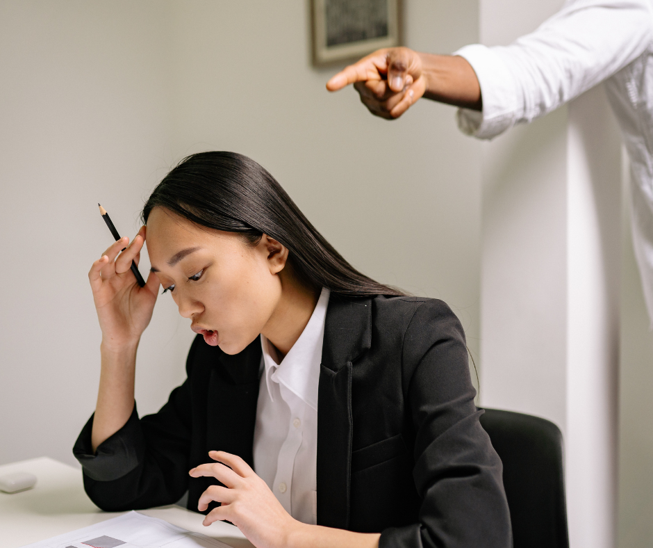 Woman frustrated at her desk with manager making demands