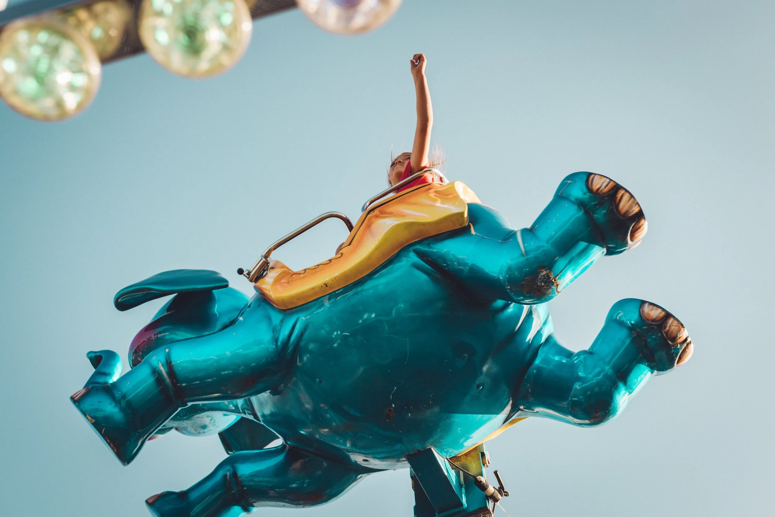 A person riding an elephant ride at an amusement park or fair. Lifestyle photography.