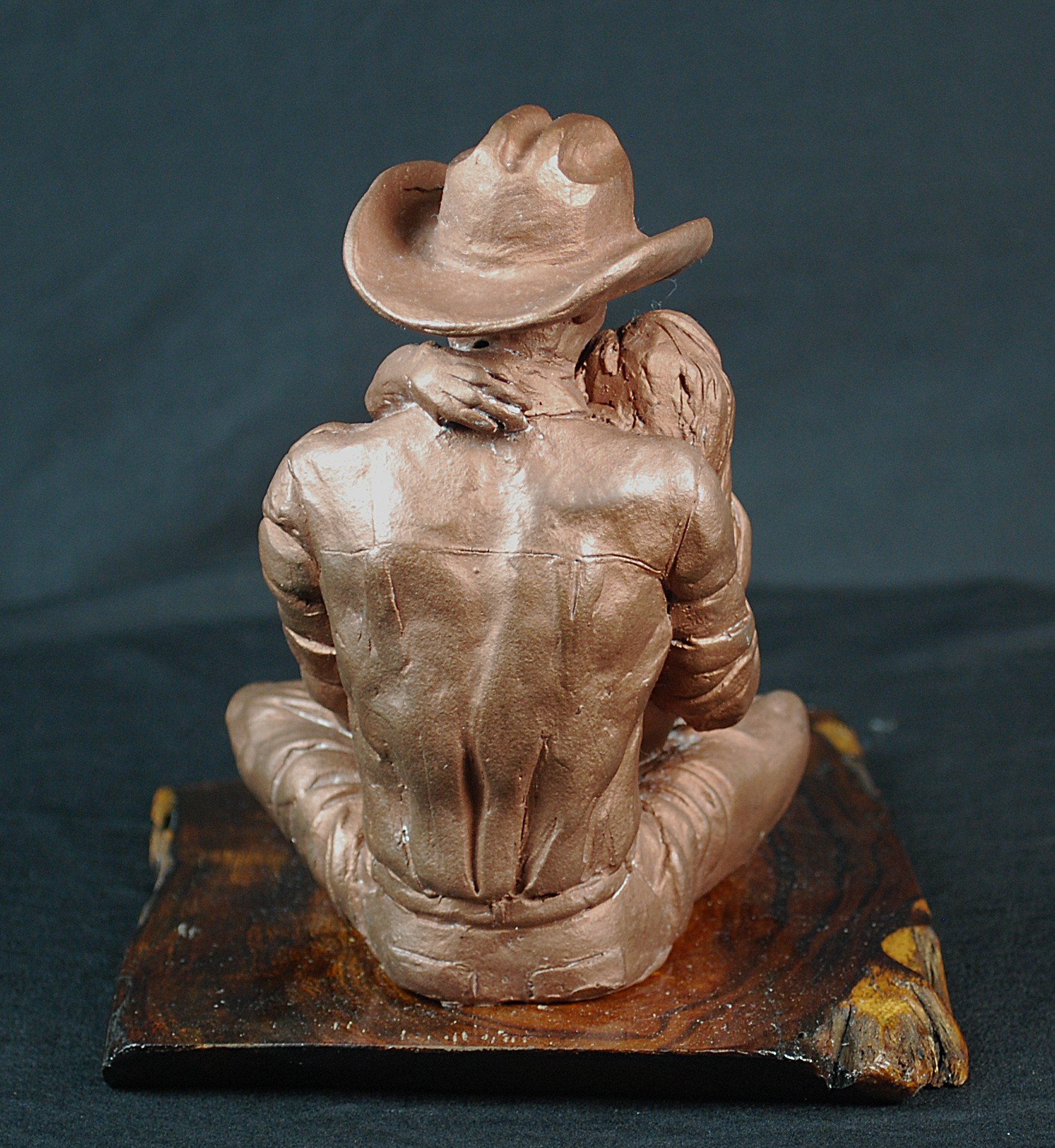 Cowboy Couple sculpture by Sharon Cruson, rear three-quarter view of seated Western couple sculpture