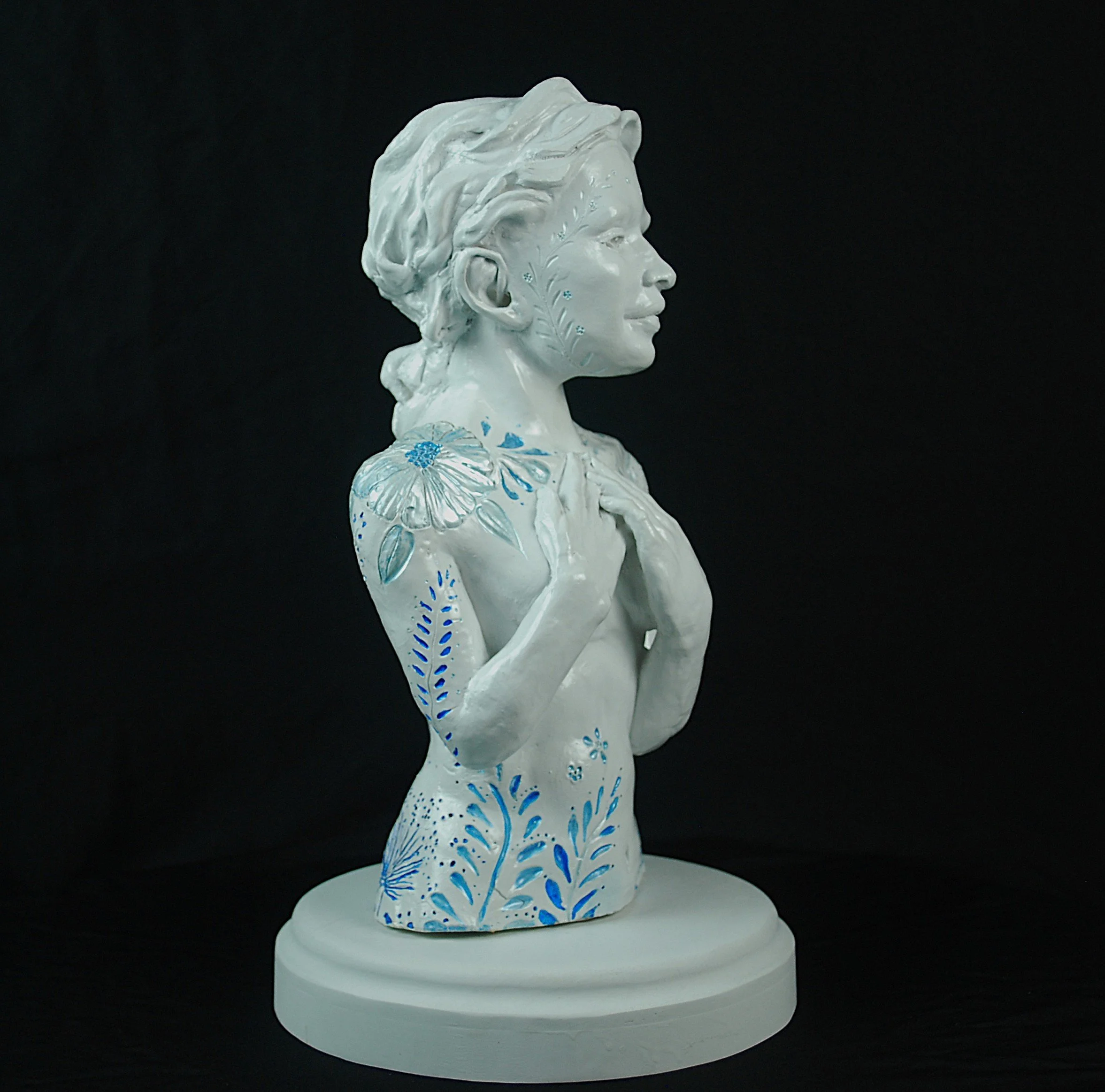 Cover Me in Springtime ceramic sculpture by Sharon Cruson, left profile view showing blue floral details