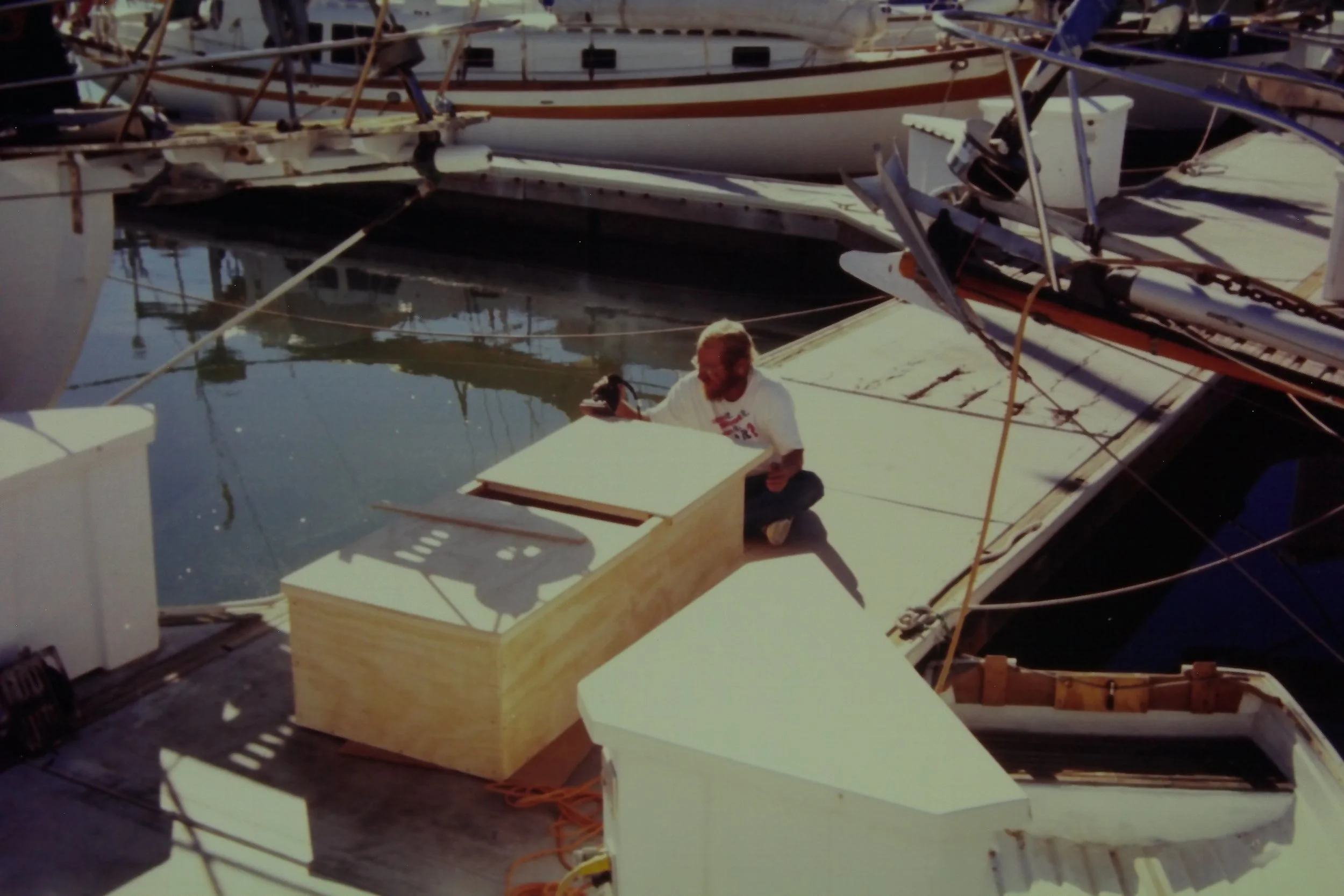  There’s Dad, forever utilizing his many skills! You can see the hard dinghy there, in the water off  to the right.  I can’t help but wonder what caused all the damage to the concrete section of the dock behind Dad. Sheesh! 