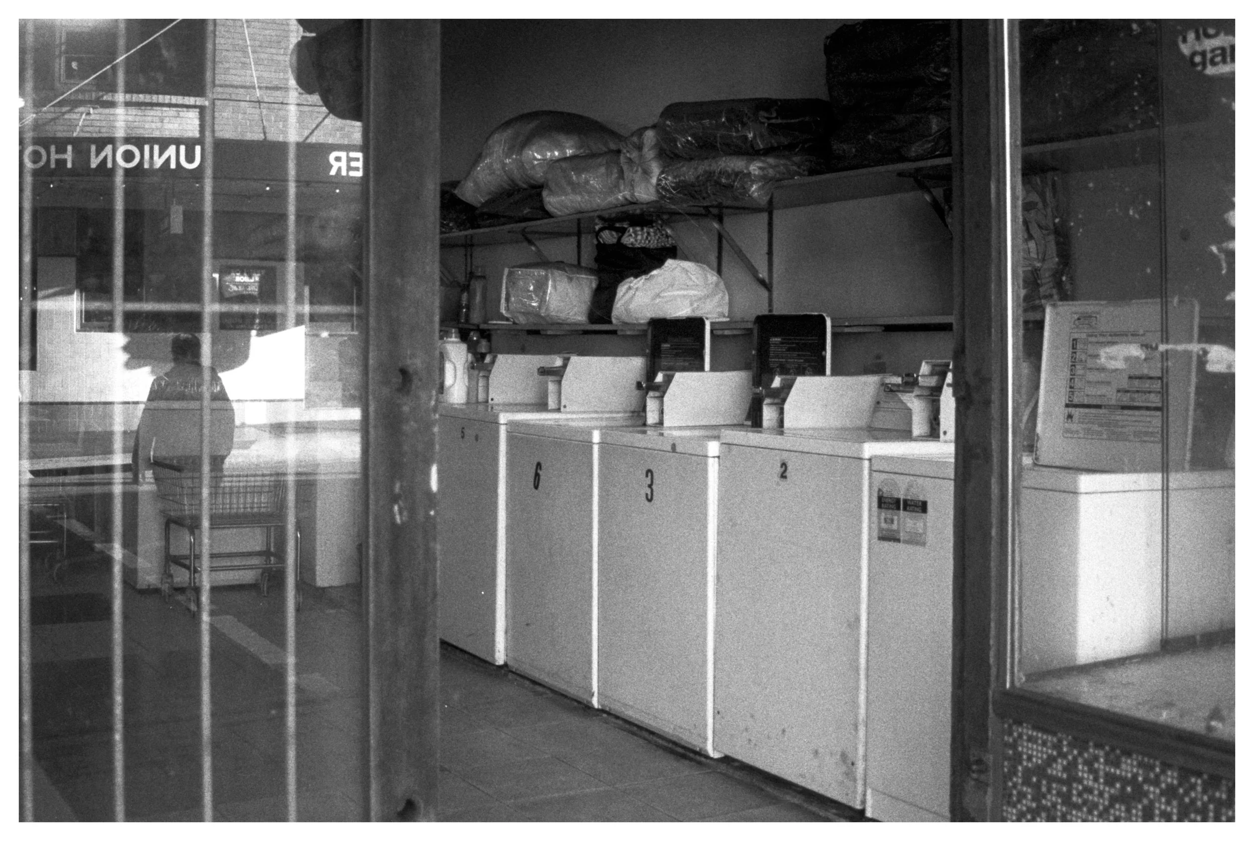 [Palimpsest by Hannah Keogh] - My photograph captures a space of familiarity yet at the same time estrangement and distance, taken in the neighbourhood of Newtown I grew up in, the location of a laundromat reflecting a local pub has undergone change 