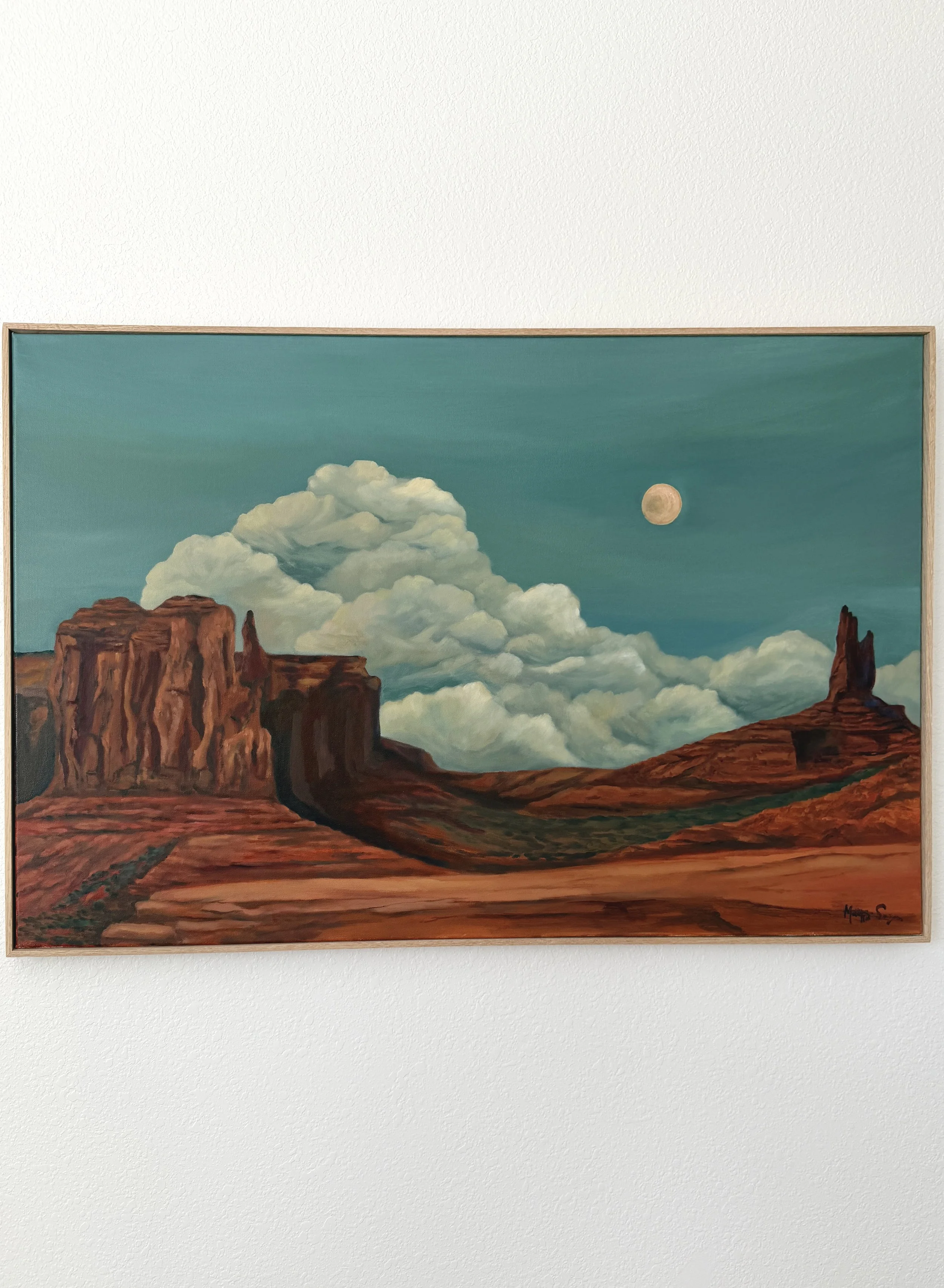 Painting of rock formations, clouds, and a full moon in the sky.