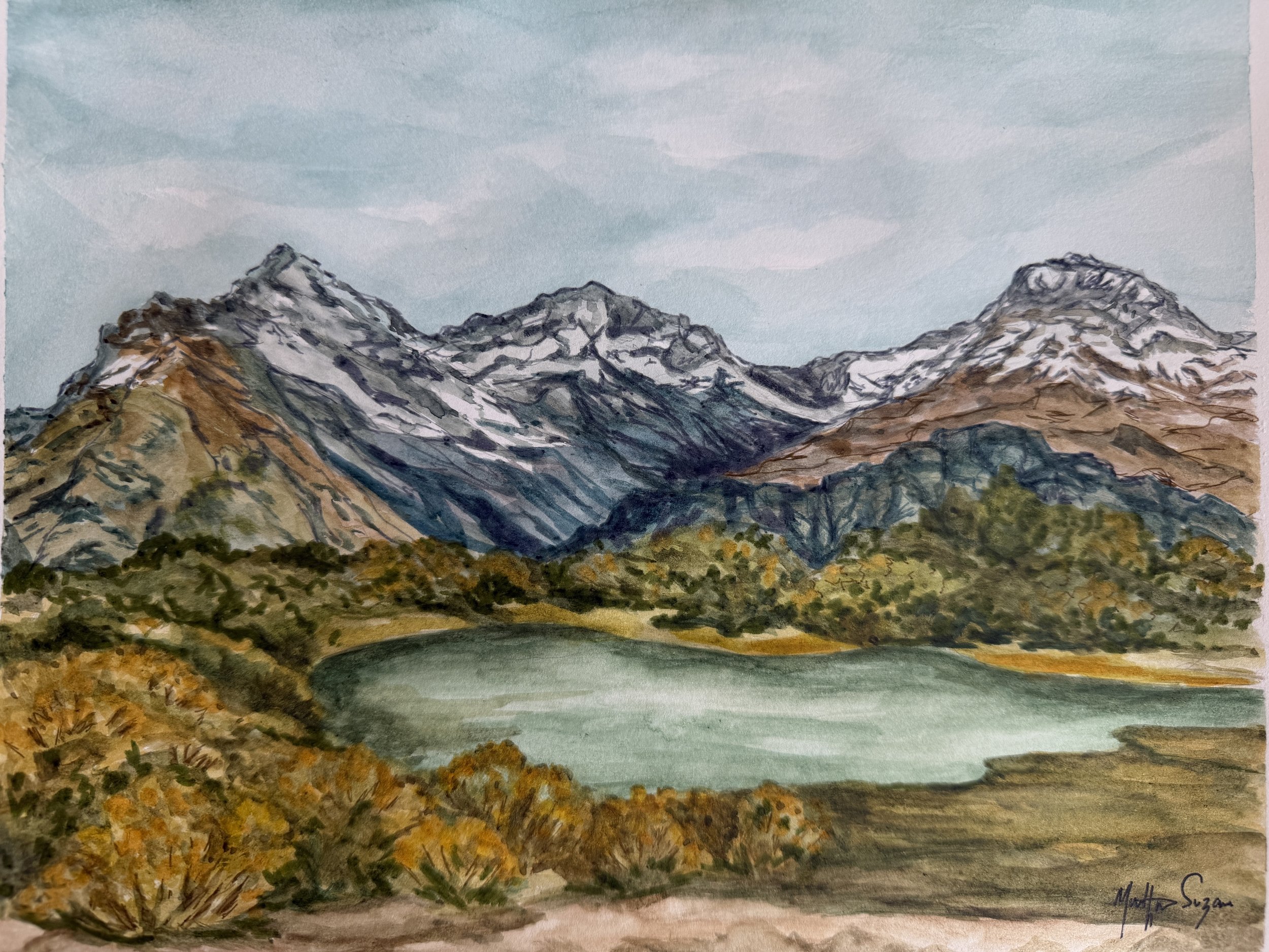 A watercolor painting of a mountain range with snow-capped peaks, a body of water in the foreground, and a cloudy sky.