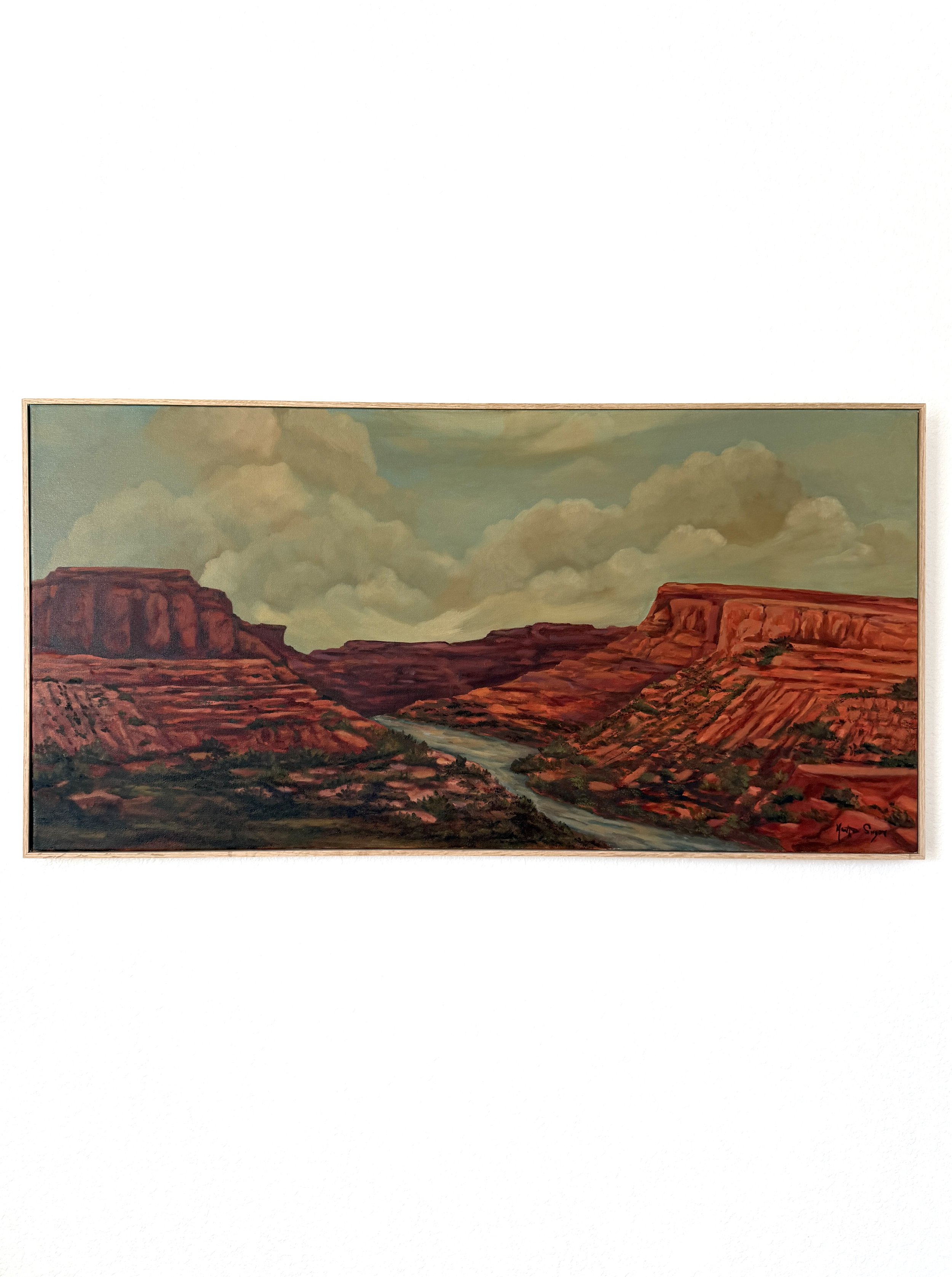 A painting of a canyon landscape with red rock formations, a river flowing through the center, and a sky with large clouds.
